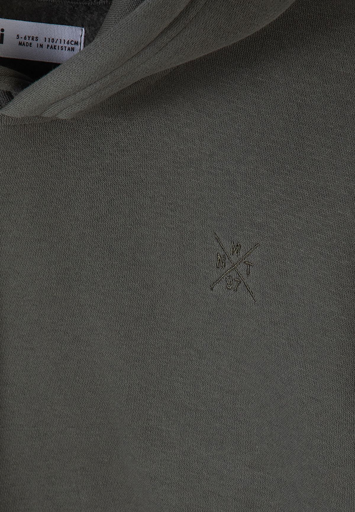 Khaki-grey hoodie chest close-up with small tonal crossed-line logo embroidery.