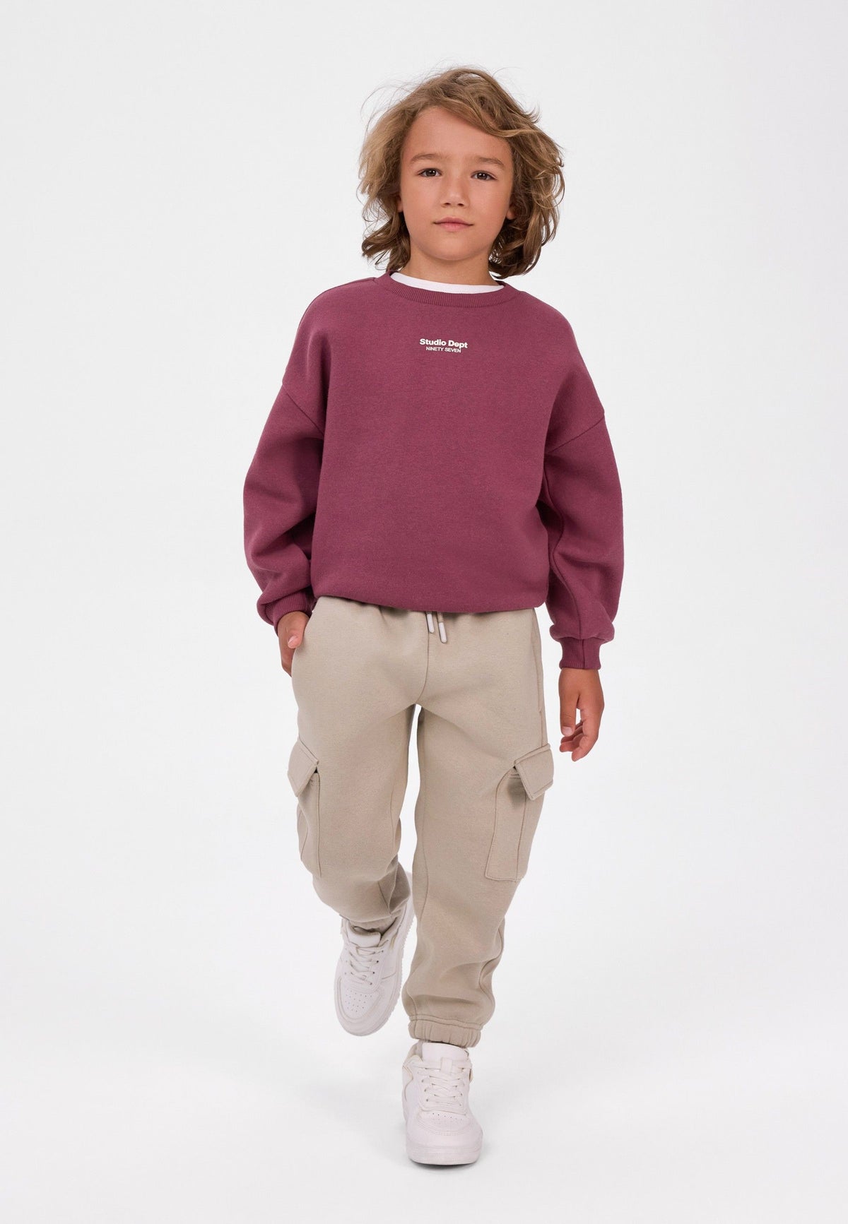 Pantaloni da jogging cargo da bambino color kaki e crema (confezione da 2), il modello in primo piano indossa i pantaloni da jogging color crema.