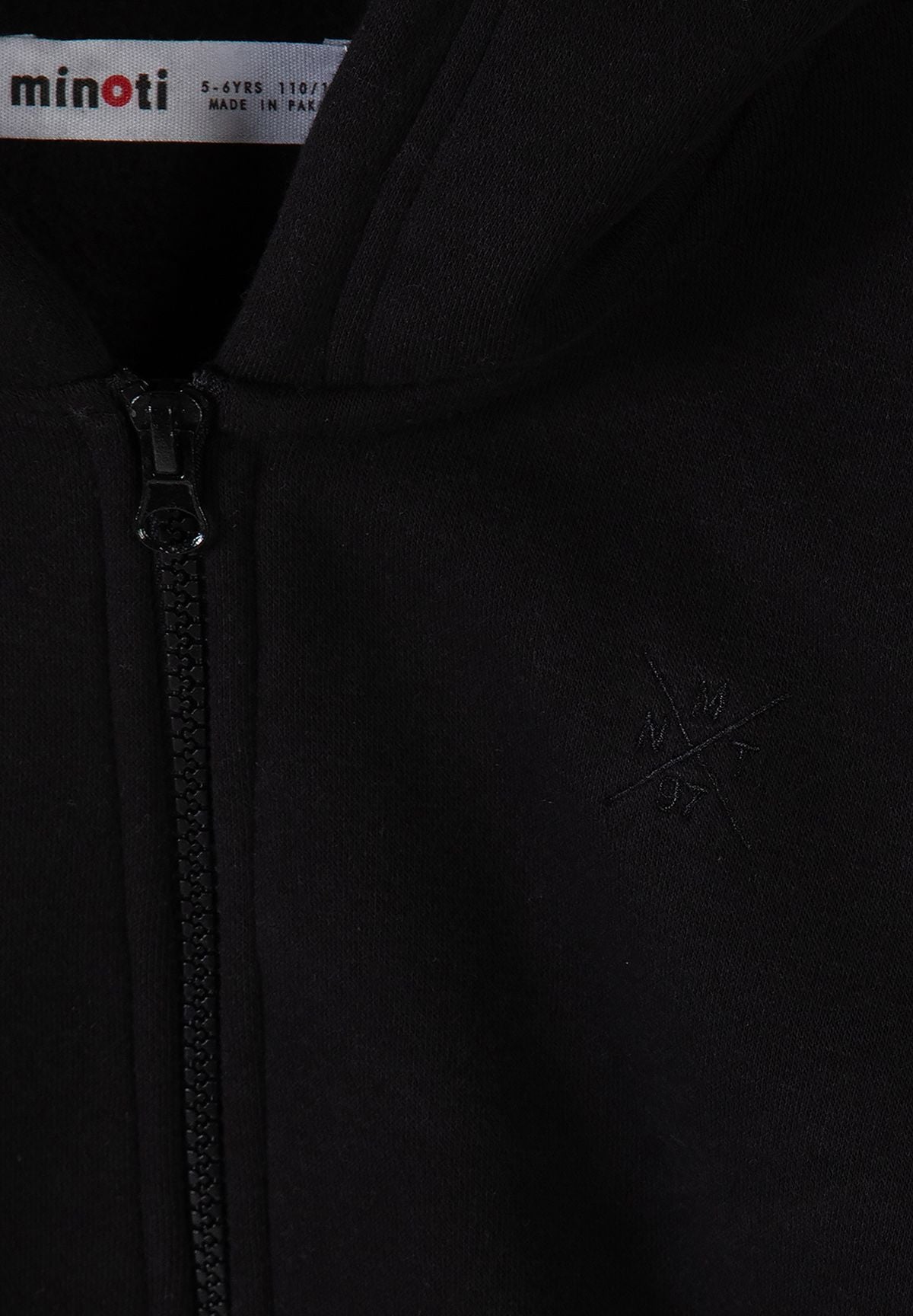 Zwart trainingspak voor jongens met een hoodie met rits en een joggingbroek, detail van de rits.