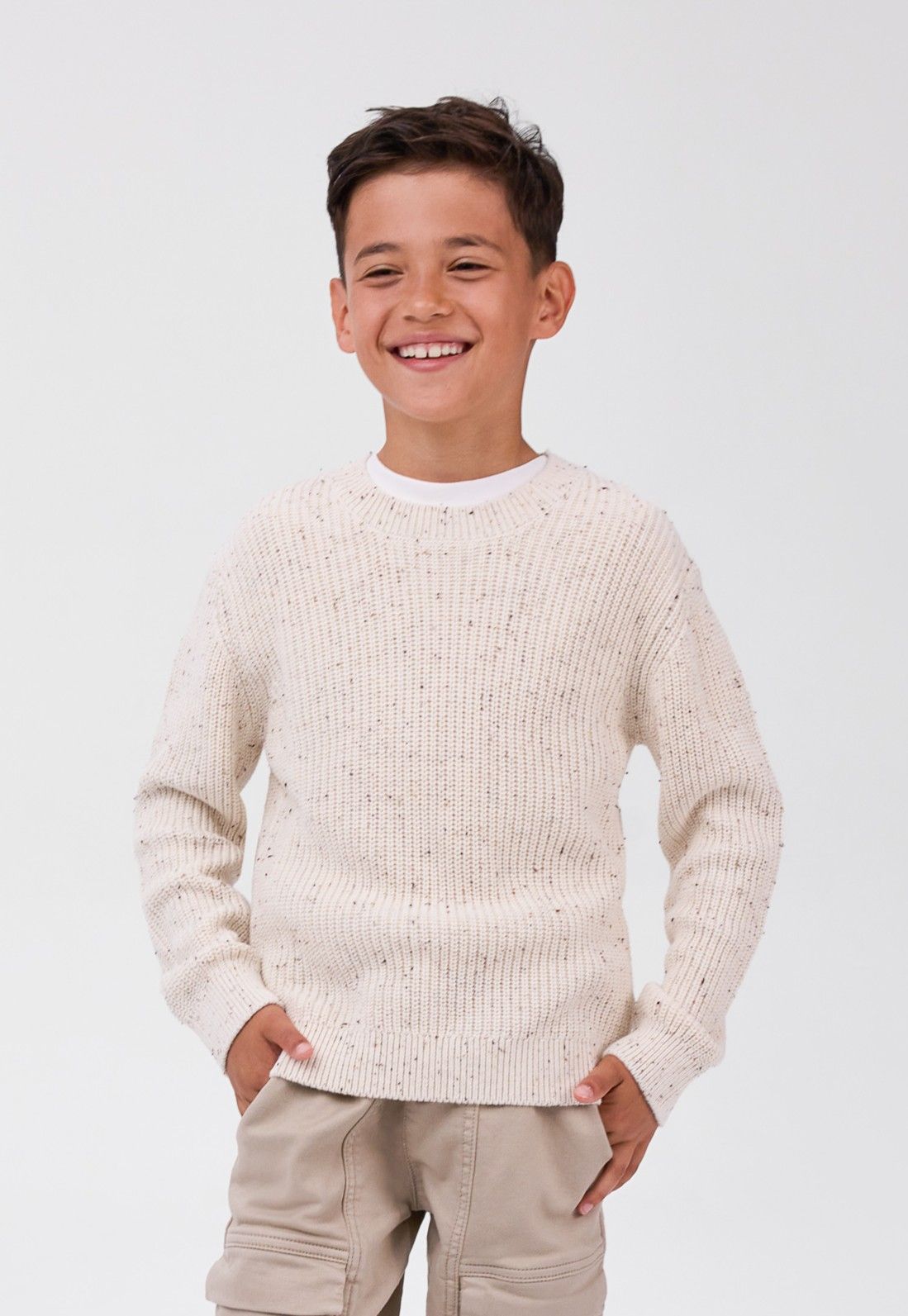 Maglione da bambino color ecru a coste con collo rotondo, modello visto di fronte.