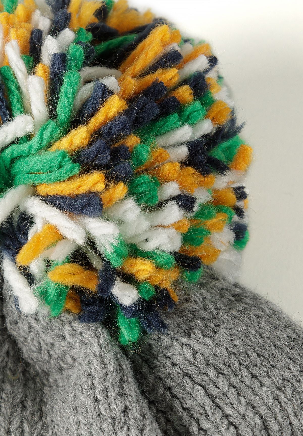 Set met grijs gemêleerde dinosaurusmuts en handschoenen voor jongens, detail van de pompon.