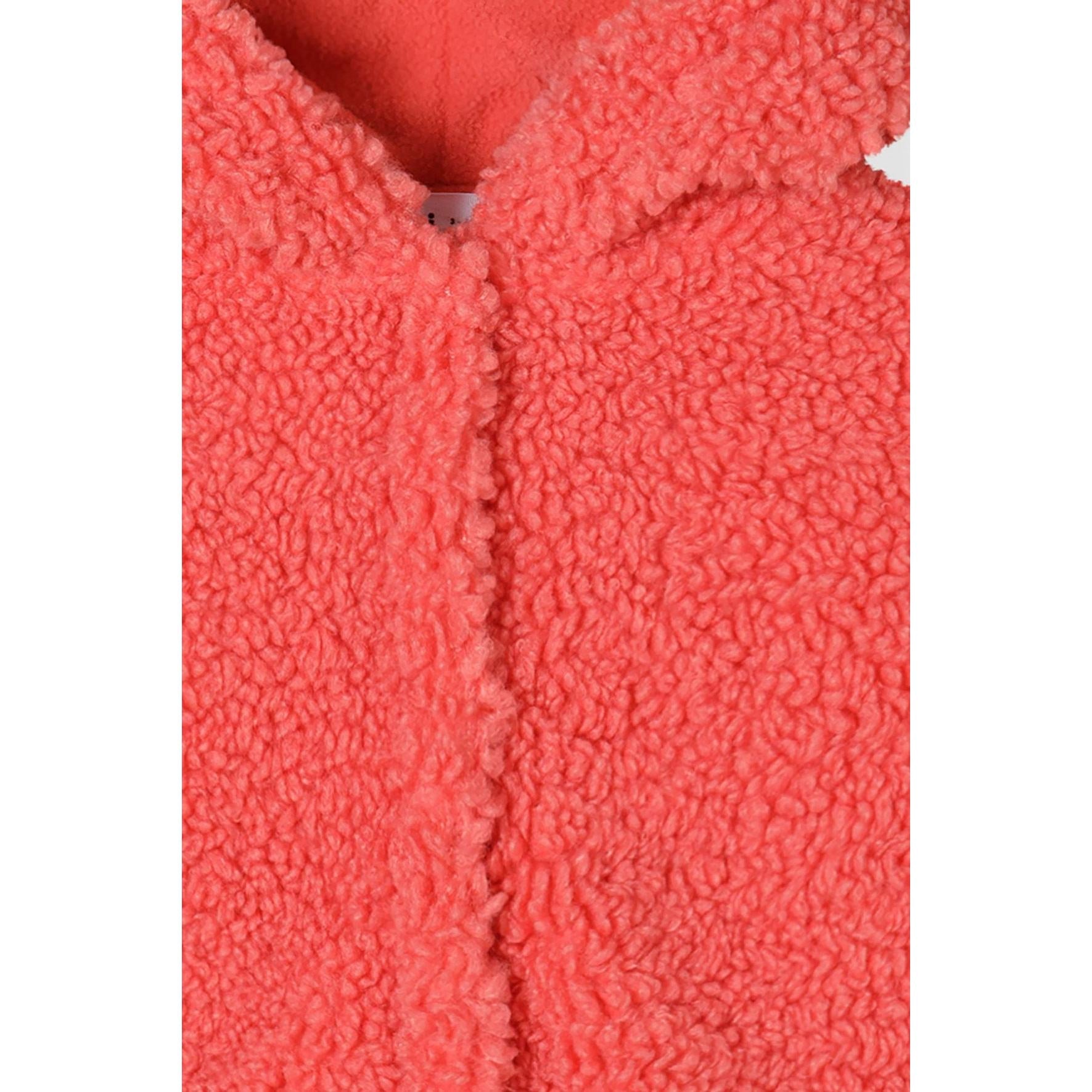 Close-up detail of coral borg fleece jacket showing concealed popper fastening system and textured fleece surface