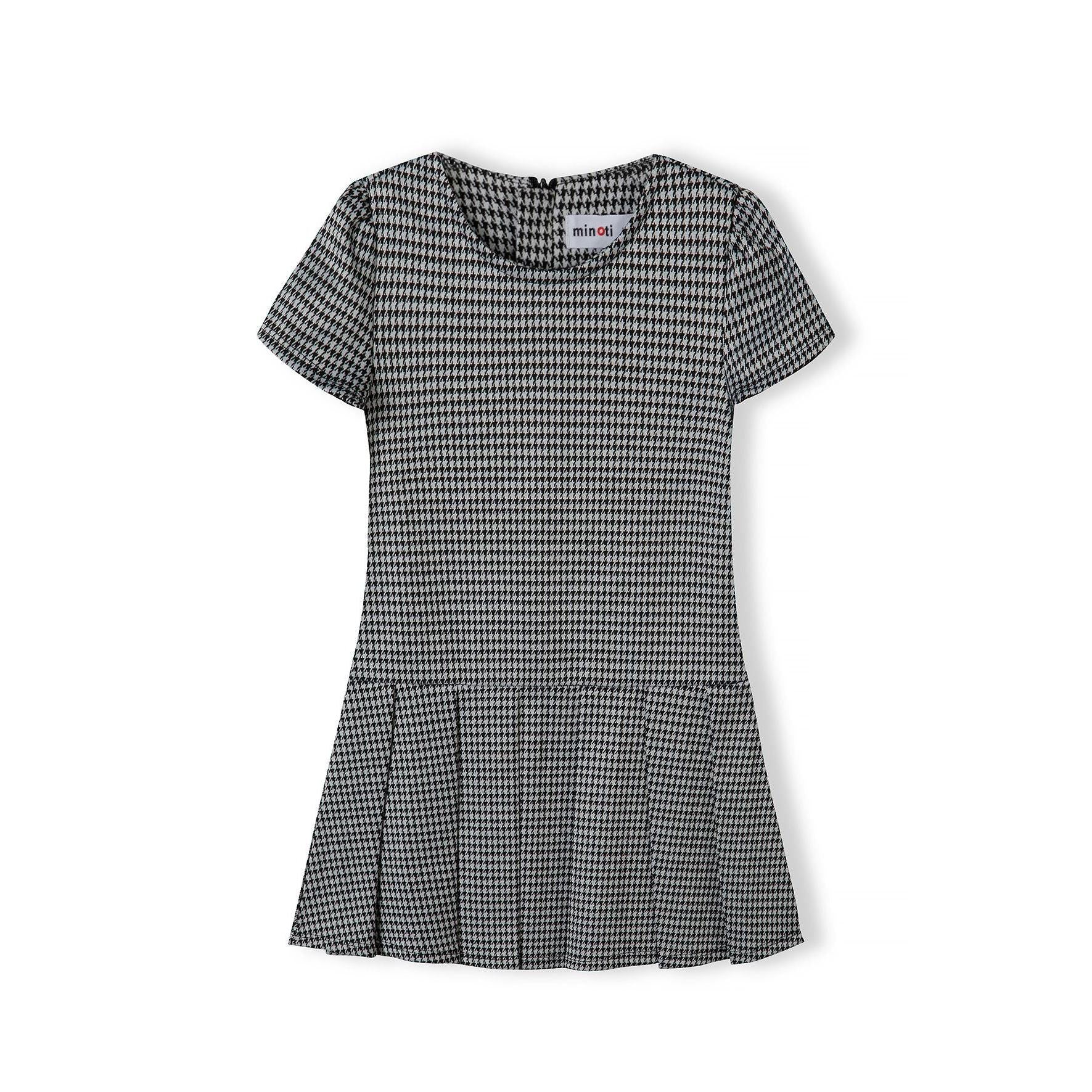 Black and white dogtooth dress laid flat showing short sleeves and pleated skirt design, back view on white background
