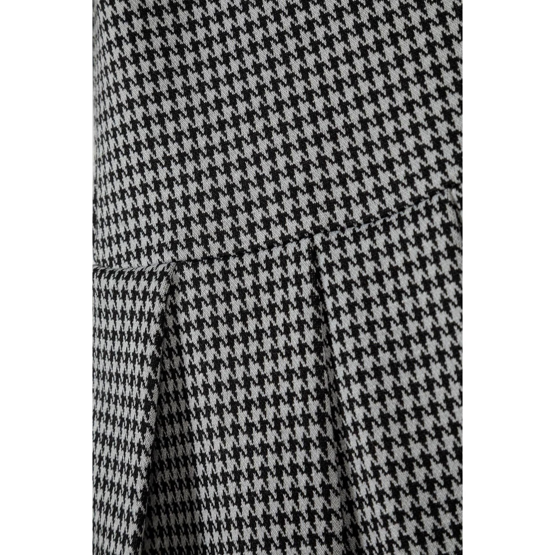 Close-up detail shot of black and white dogtooth pattern fabric texture showing the classic houndstooth weave