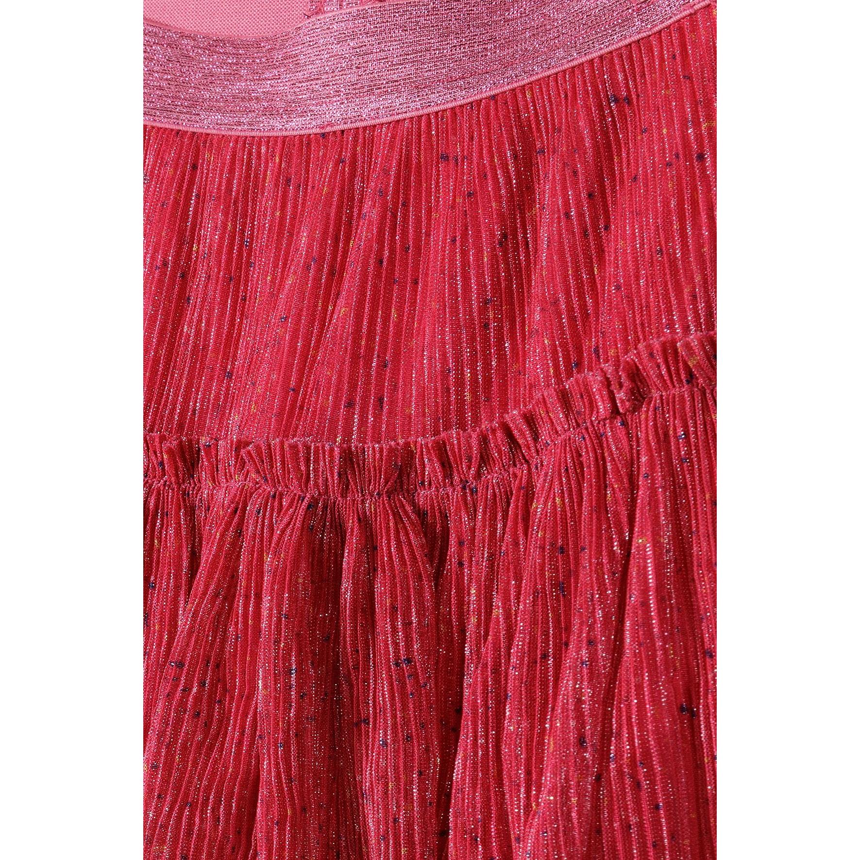 Close-up detail of pink sparkly fabric texture showing glittery waistband and gathered ruffle construction with pleated details