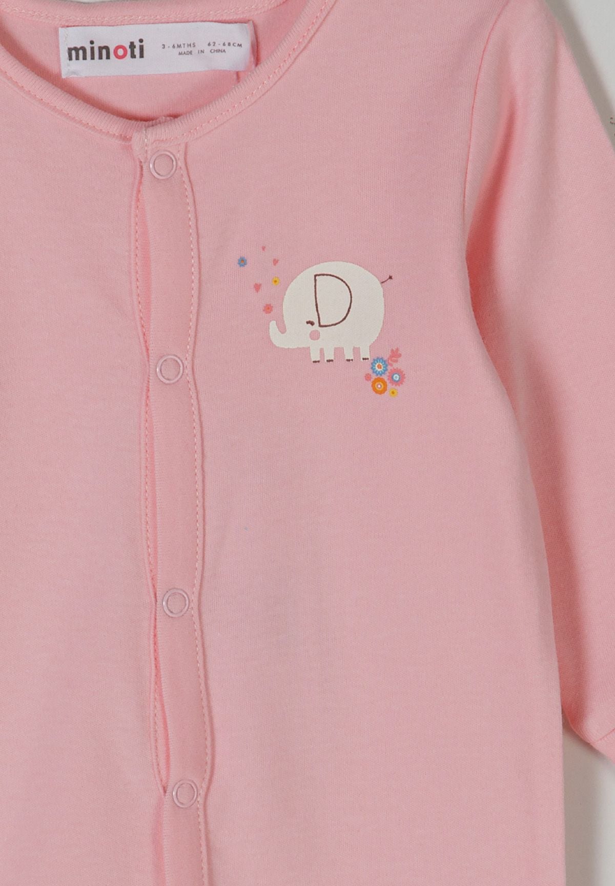 Detail of a light pink long sleeve sleepsuit with elephant print and front press stud fastening.