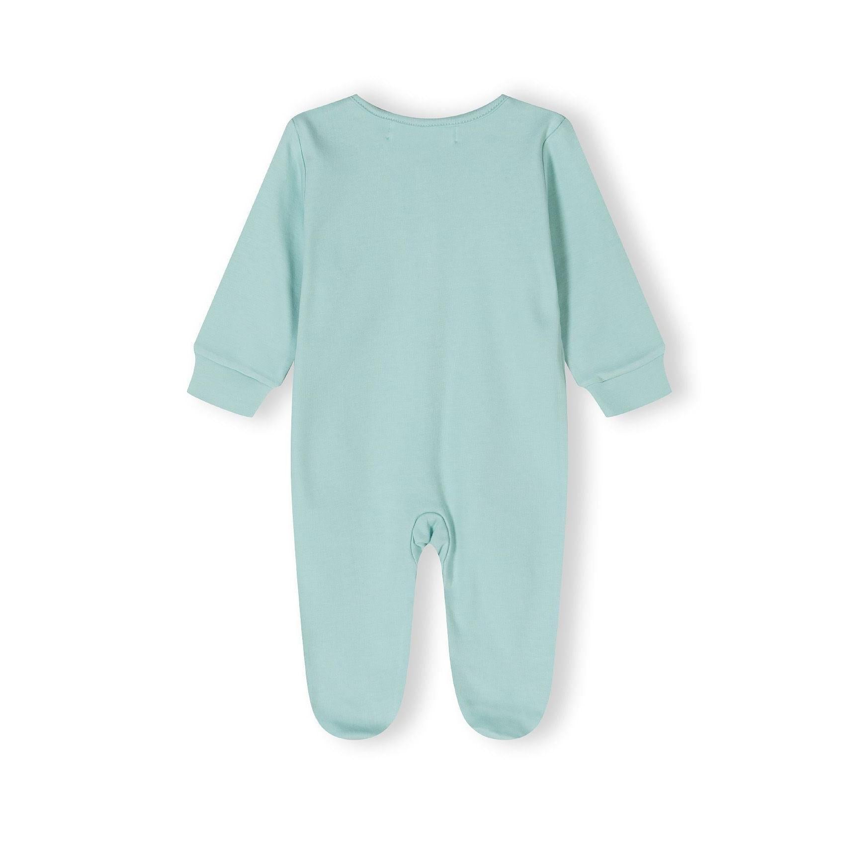 Close-up detail of mint green sleepsuit showing black outlined dinosaur prints and snap button fastenings with Minoti label