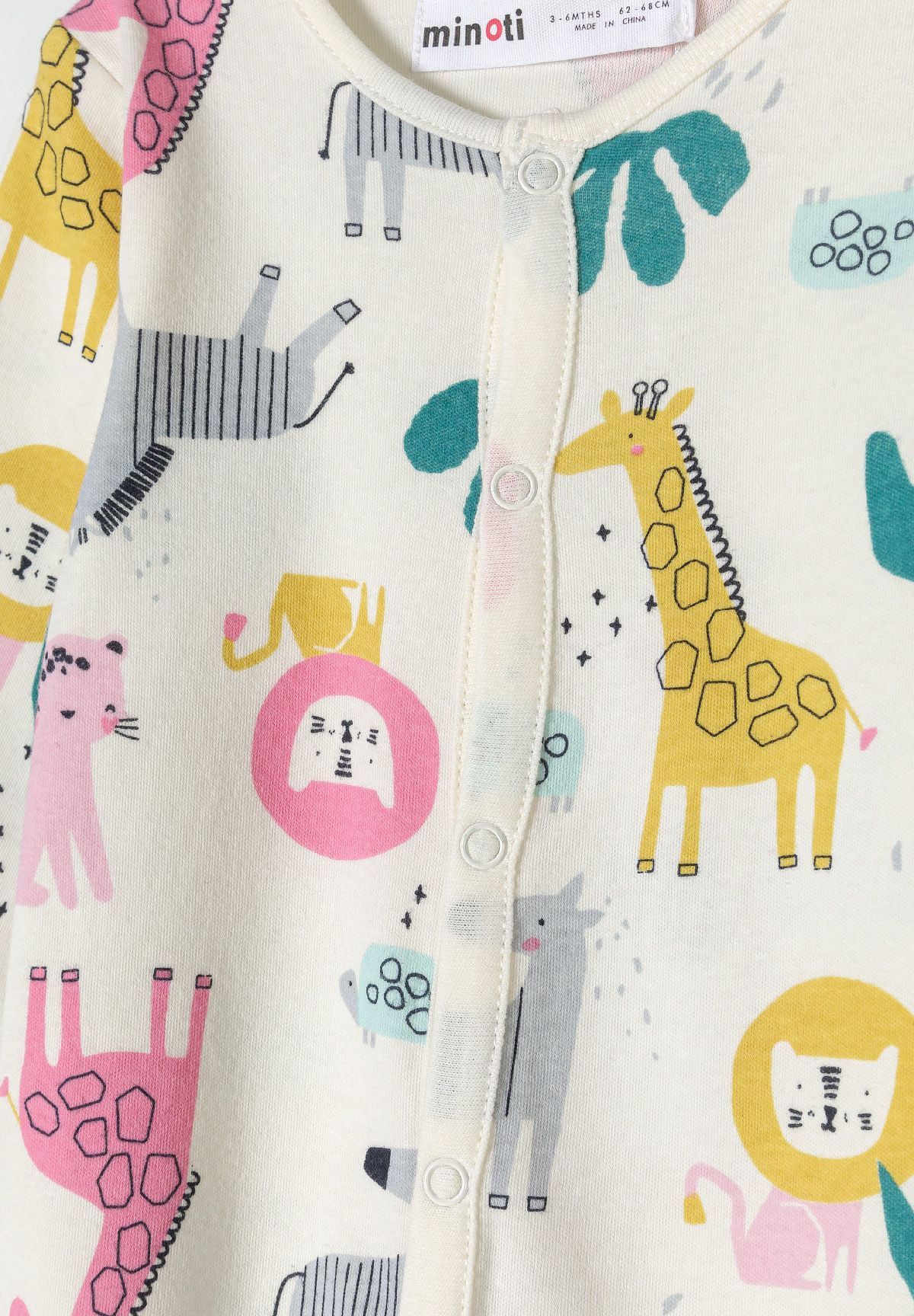 Detail of a girls' sleepsuit with colorful animal prints and press studs.