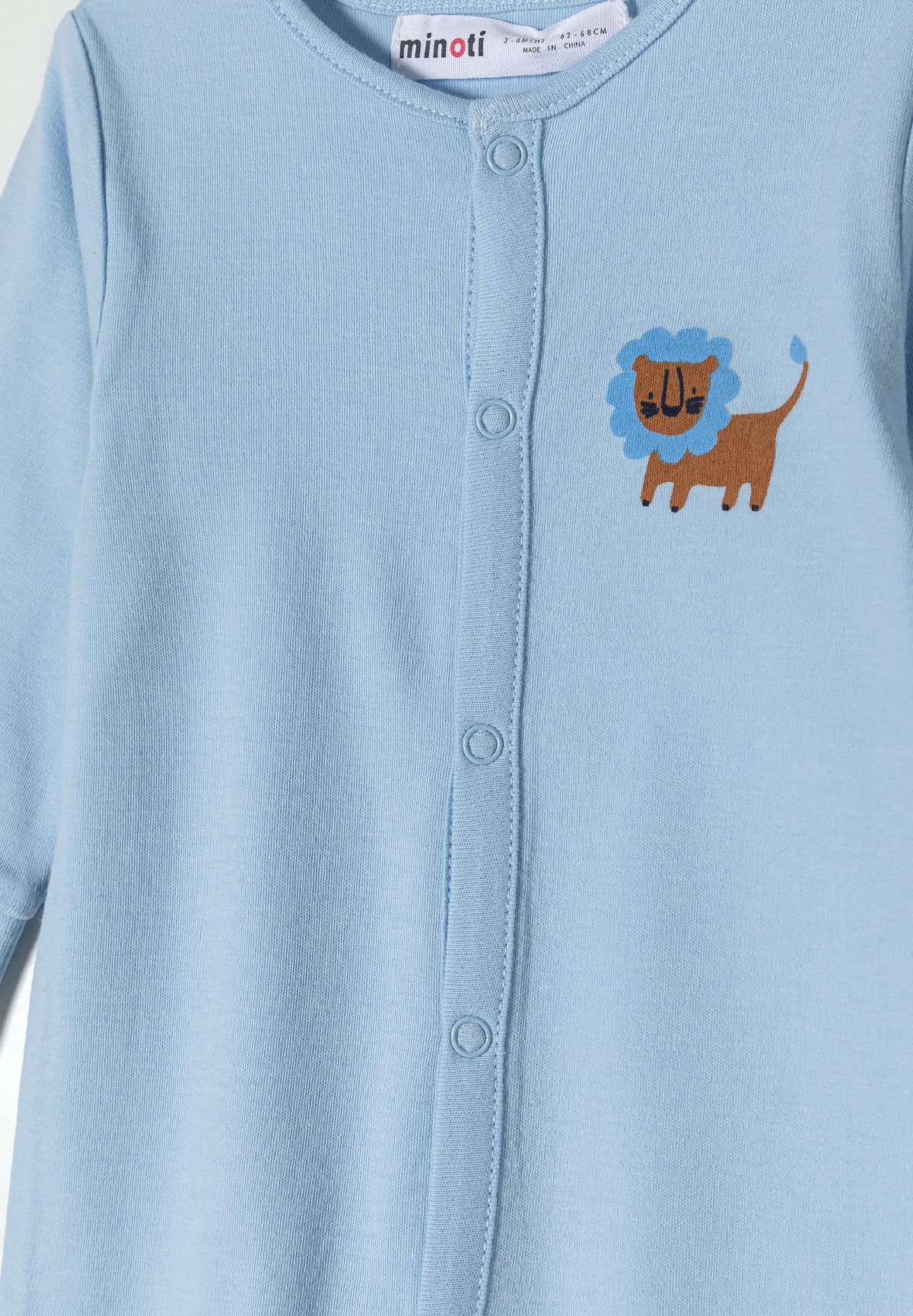 Detail of light blue long sleeve sleepsuit for boys with lion print and press studs.