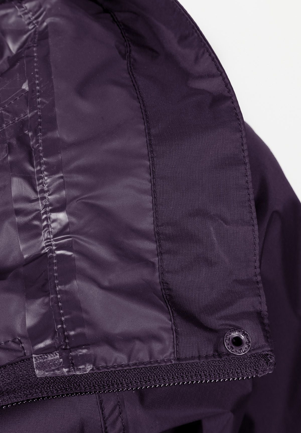 Detail of a women's packaway waterproof jacket in purple, featuring a hood and zip fastening.