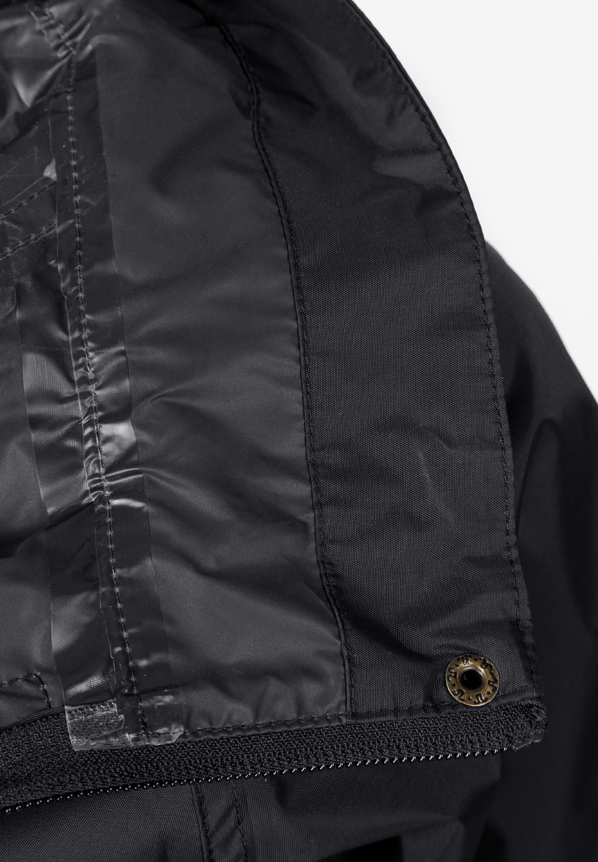 Close-up of the inside seam on the black packaway hooded jacket.