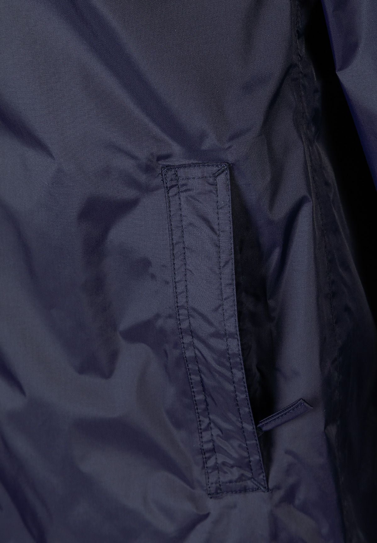 Detail of navy waterproof jacket showing zipped pocket.