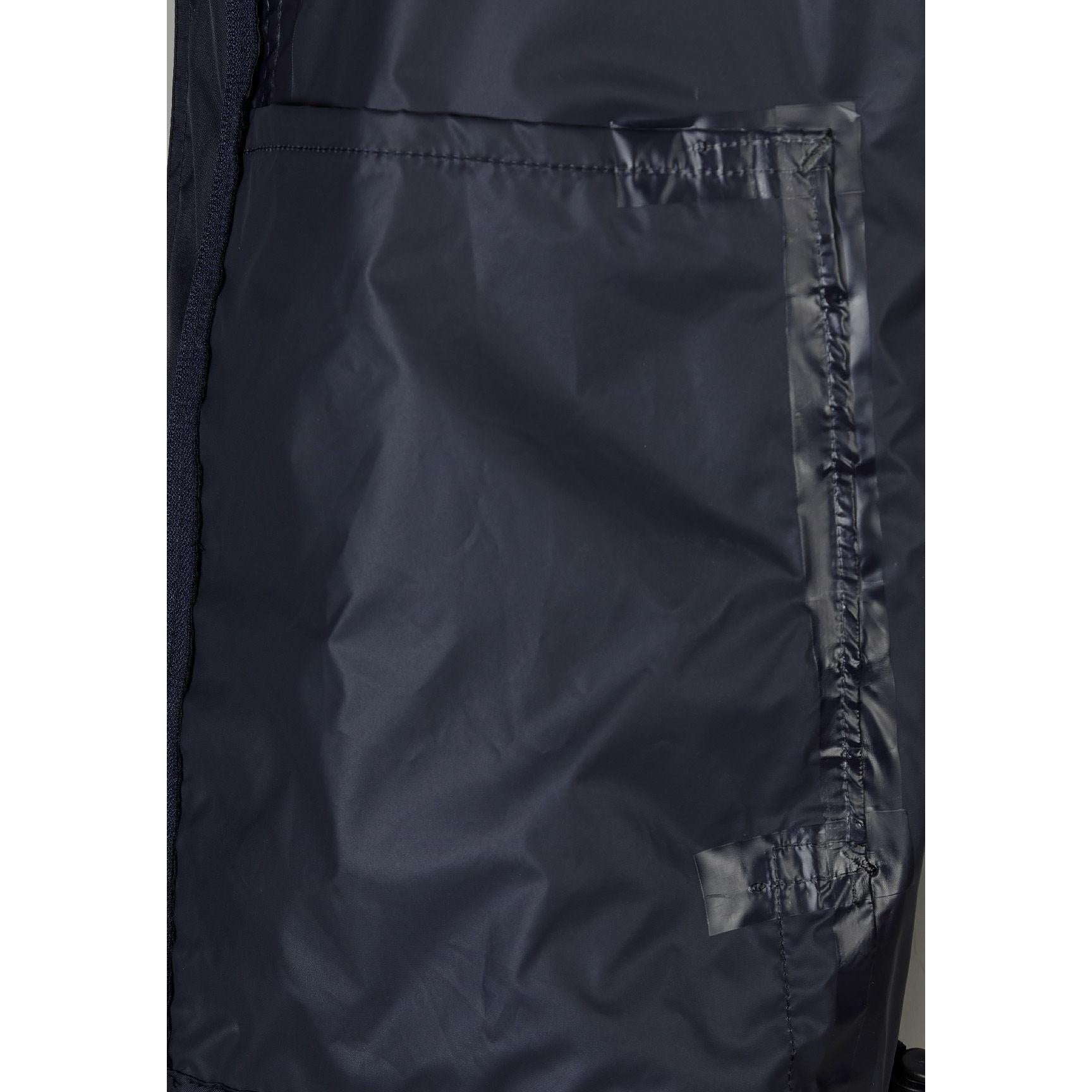 Close-up detail of navy jacket interior showing internal zip pocket and waterproof lining construction