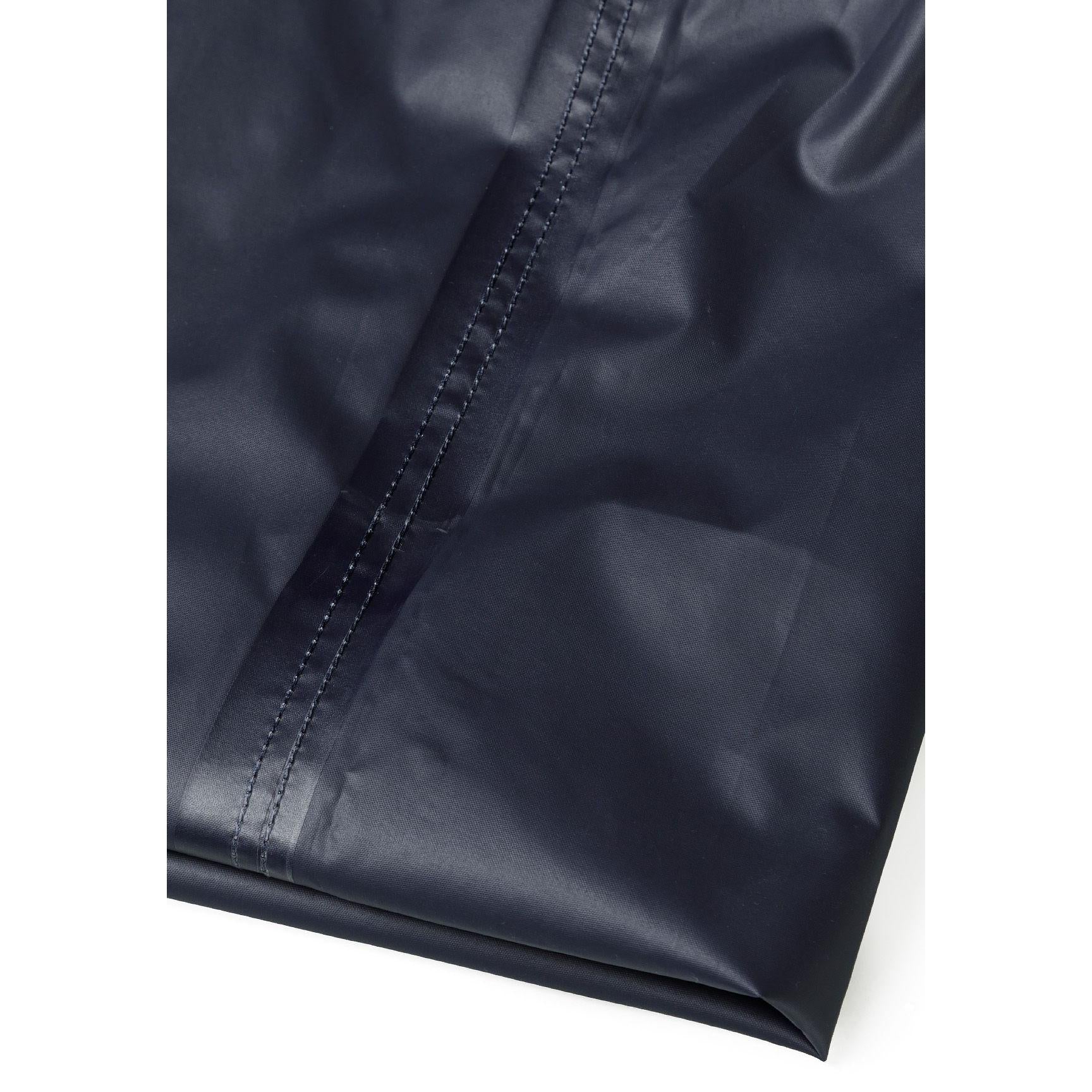 Close-up detail of navy waterproof overpants showing elastic waistband and waterproof fabric texture