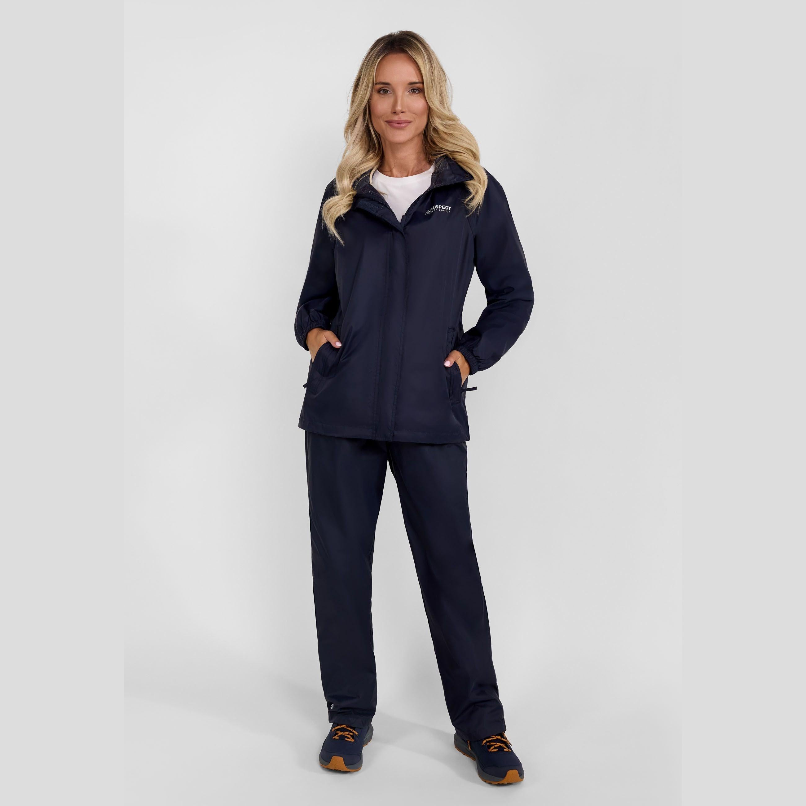 Woman wearing navy waterproof overpants and matching jacket against white background, full body front view