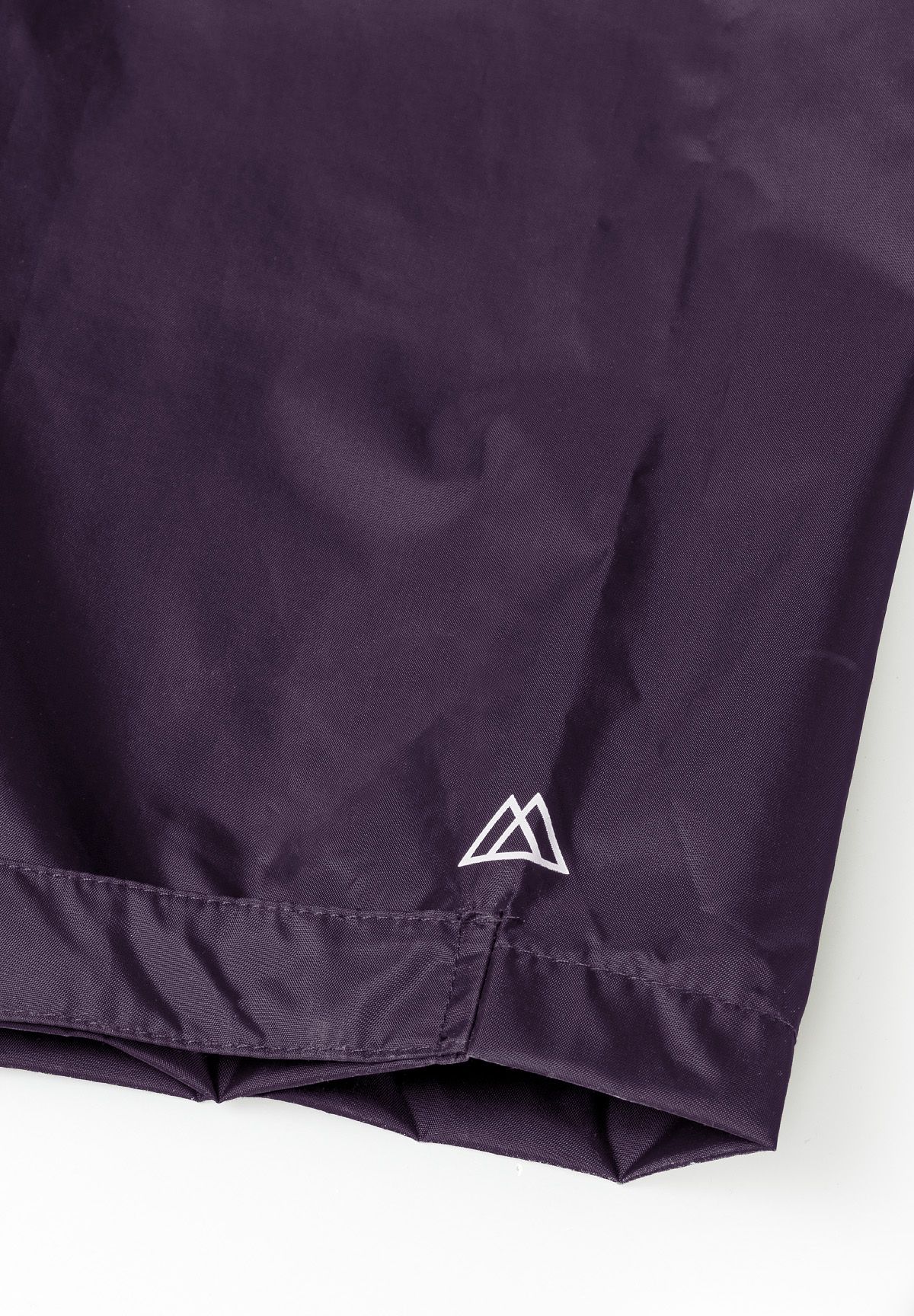 Close-up of purple waterproof overpants with adjustable cuffs and logo.
