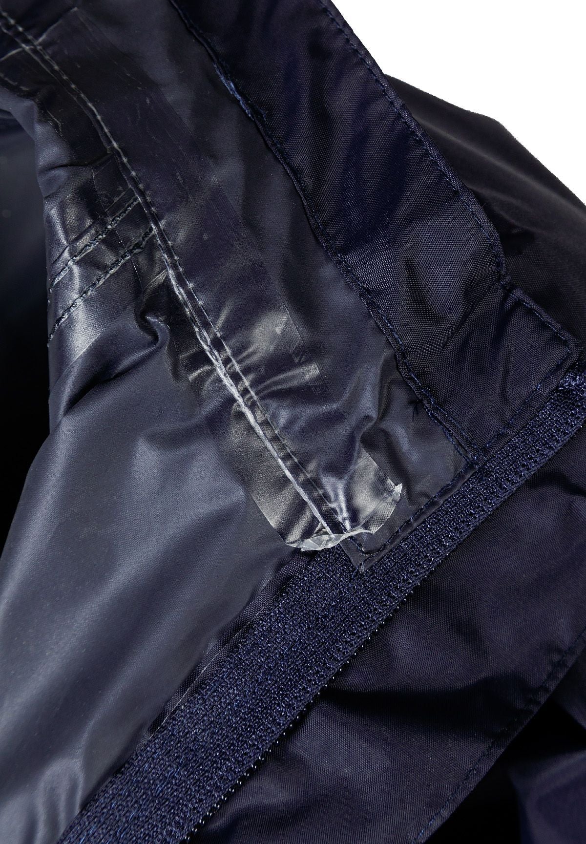 Close-up of the inside seam on the navy packaway hooded jacket.