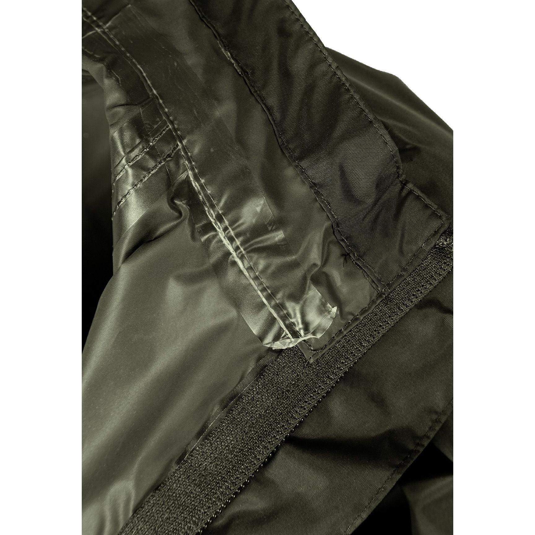 Close-up detail of khaki jacket's interior showing packaway storage pocket with zipper