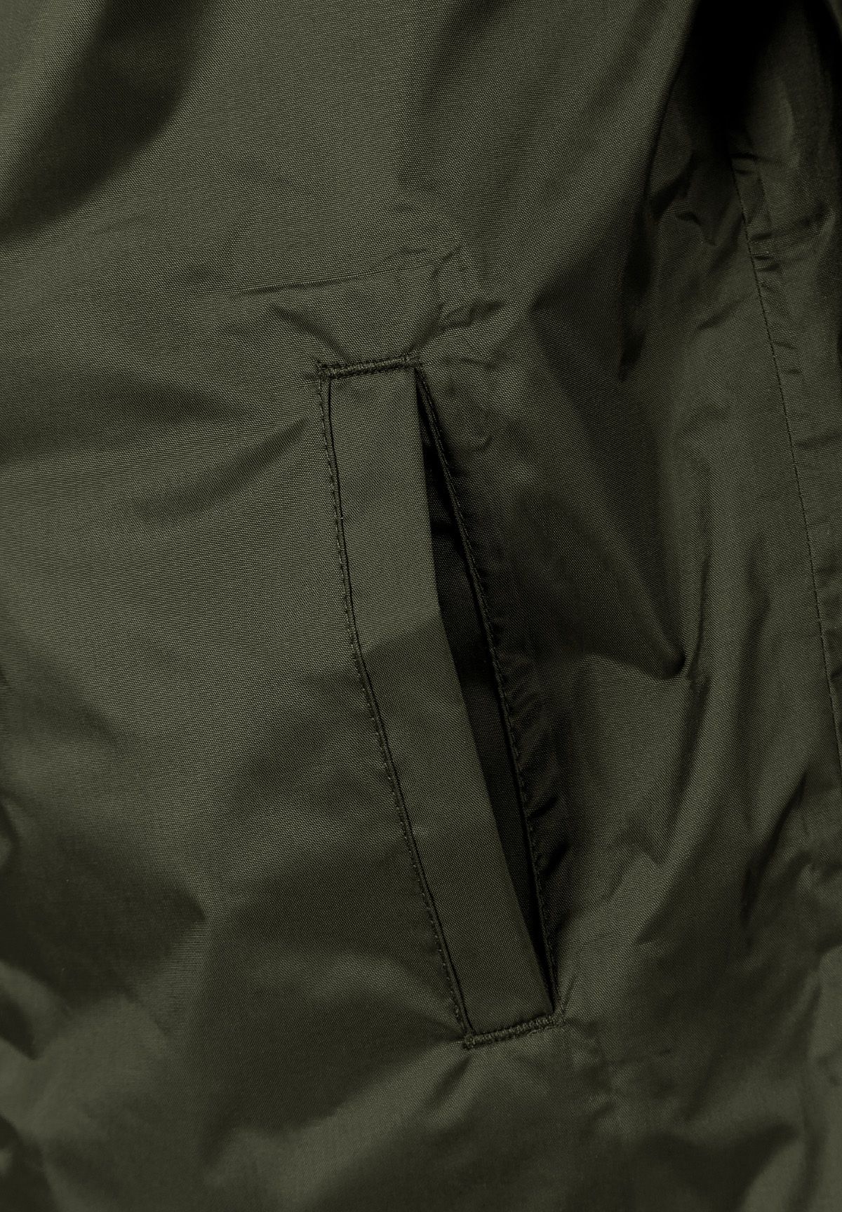 Detail of a khaki kids waterproof jacket showing a side pocket.