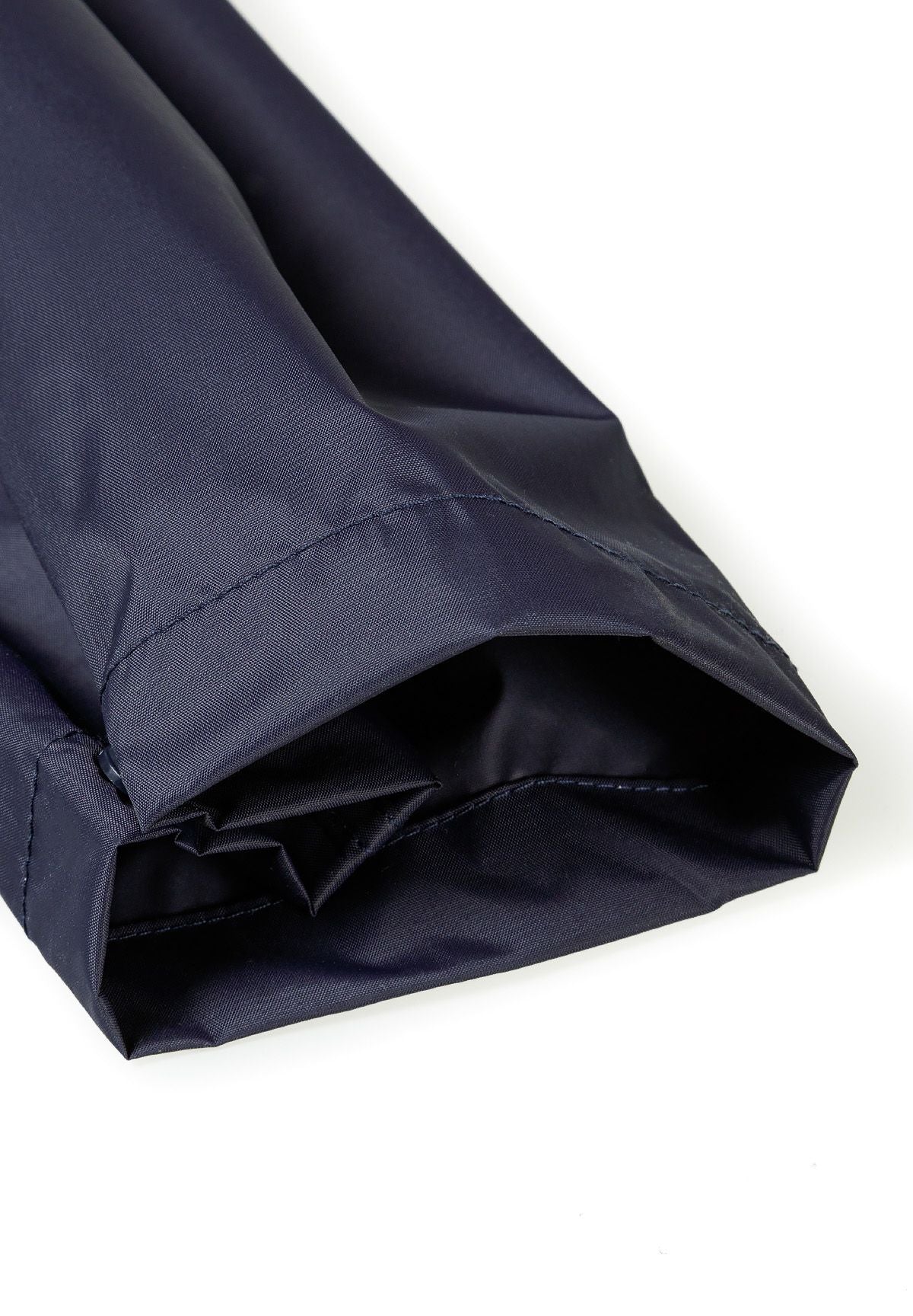 Detail of navy waterproof overpants for kids with elasticated ankle cuffs.