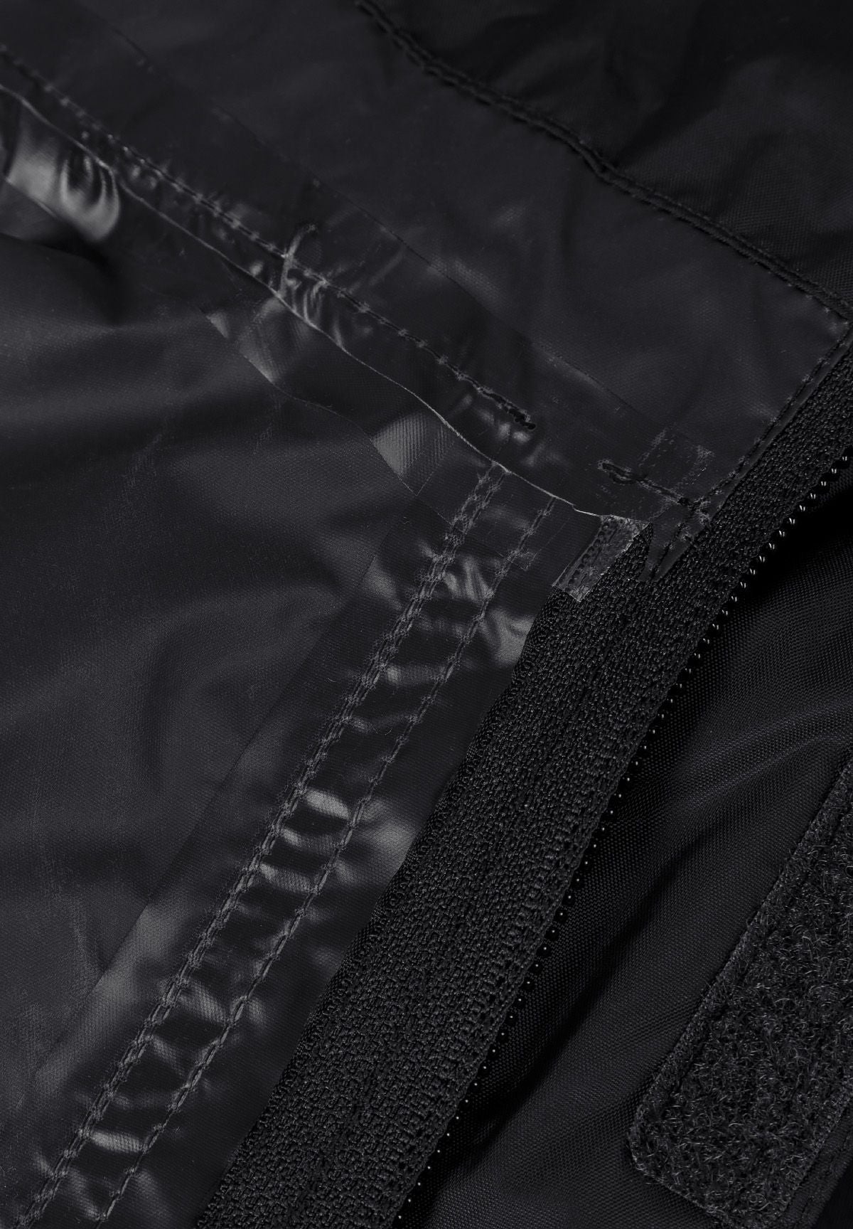 Detail of a black waterproof jacket showing zip and seam features.
