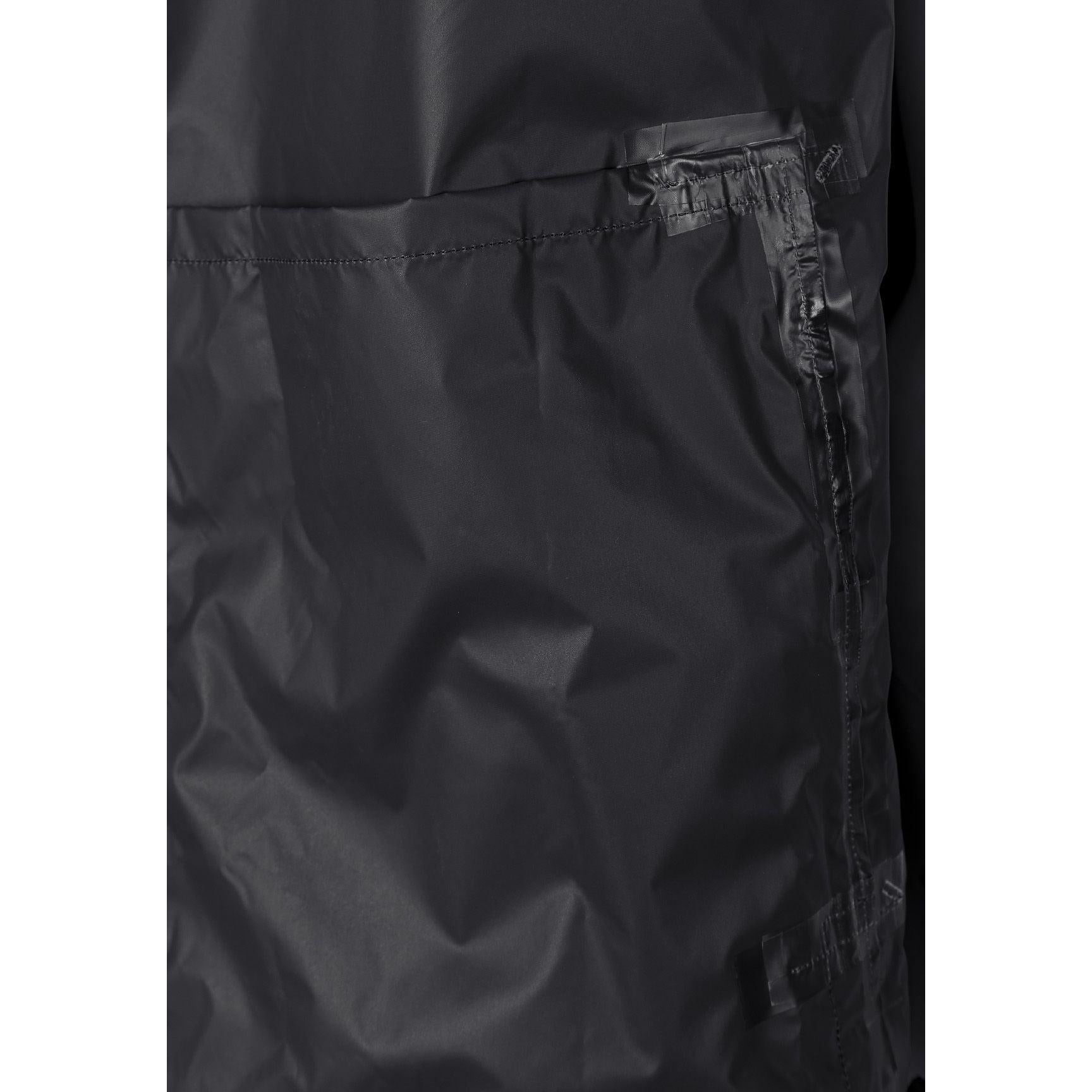 Close-up detail of black waterproof jacket interior showing taped seams and zip construction for weather protection