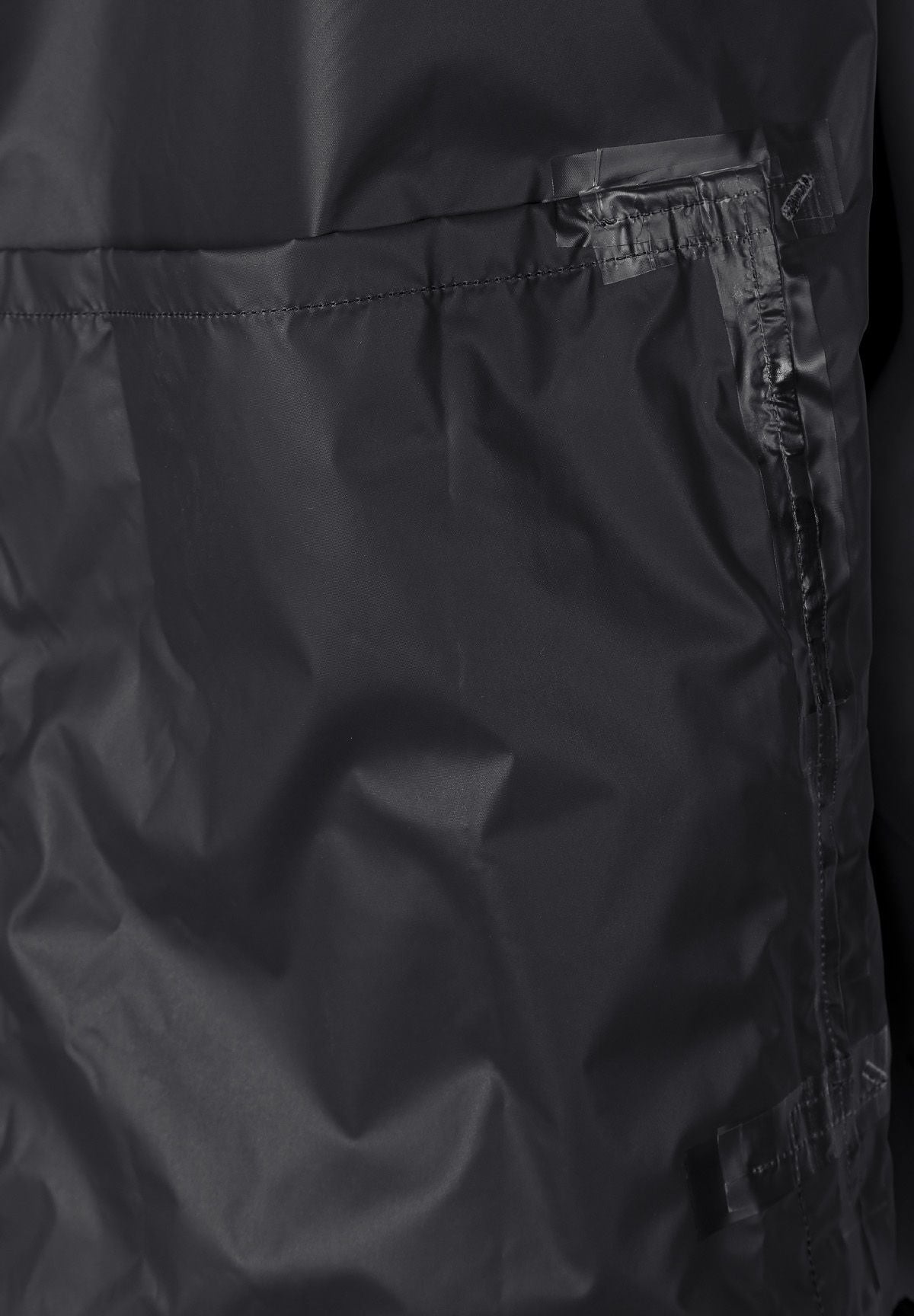 Detail of a black men's waterproof jacket featuring a zip pocket and smooth fabric.