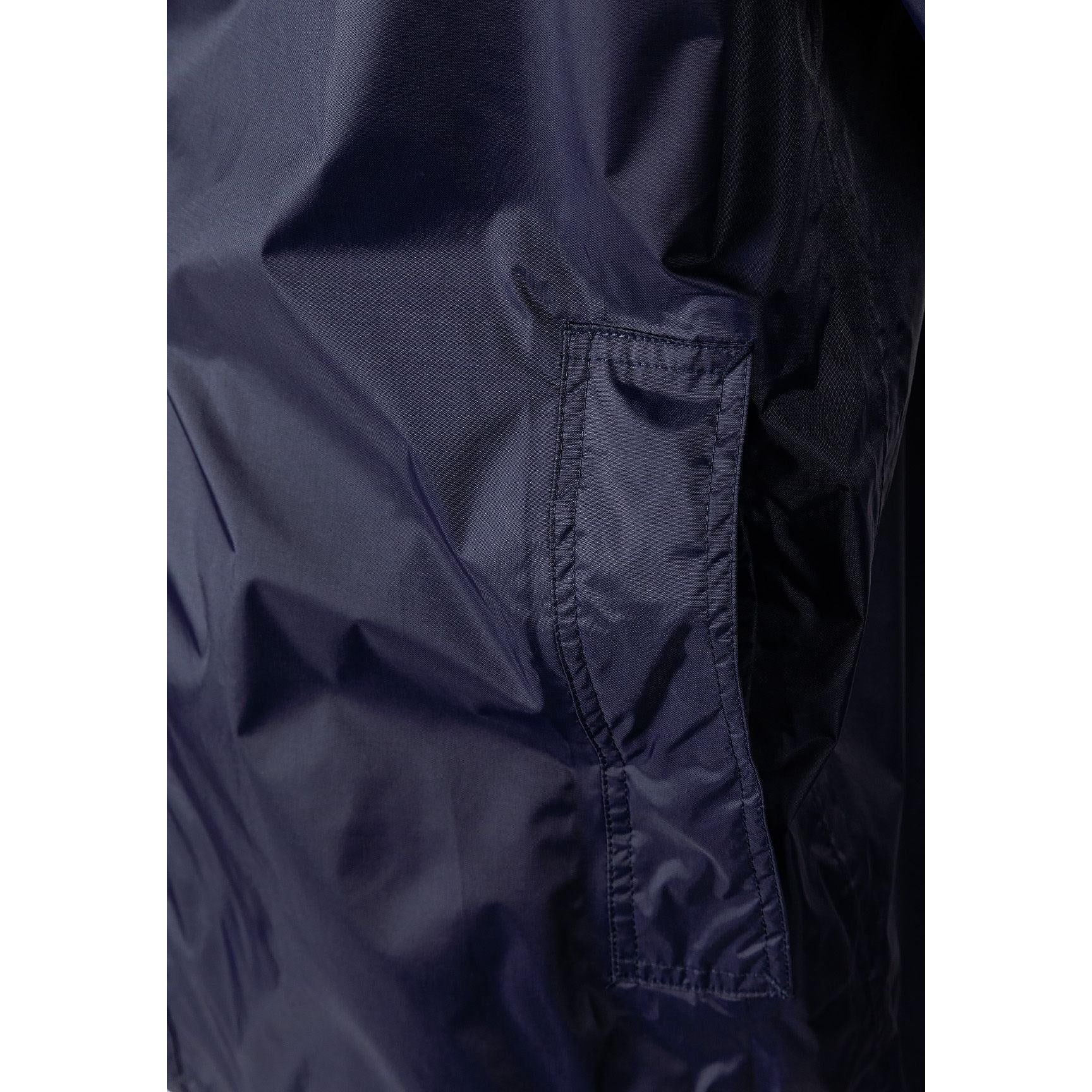Close-up detail of navy jacket interior showing zip pocket construction and waterproof fabric lining