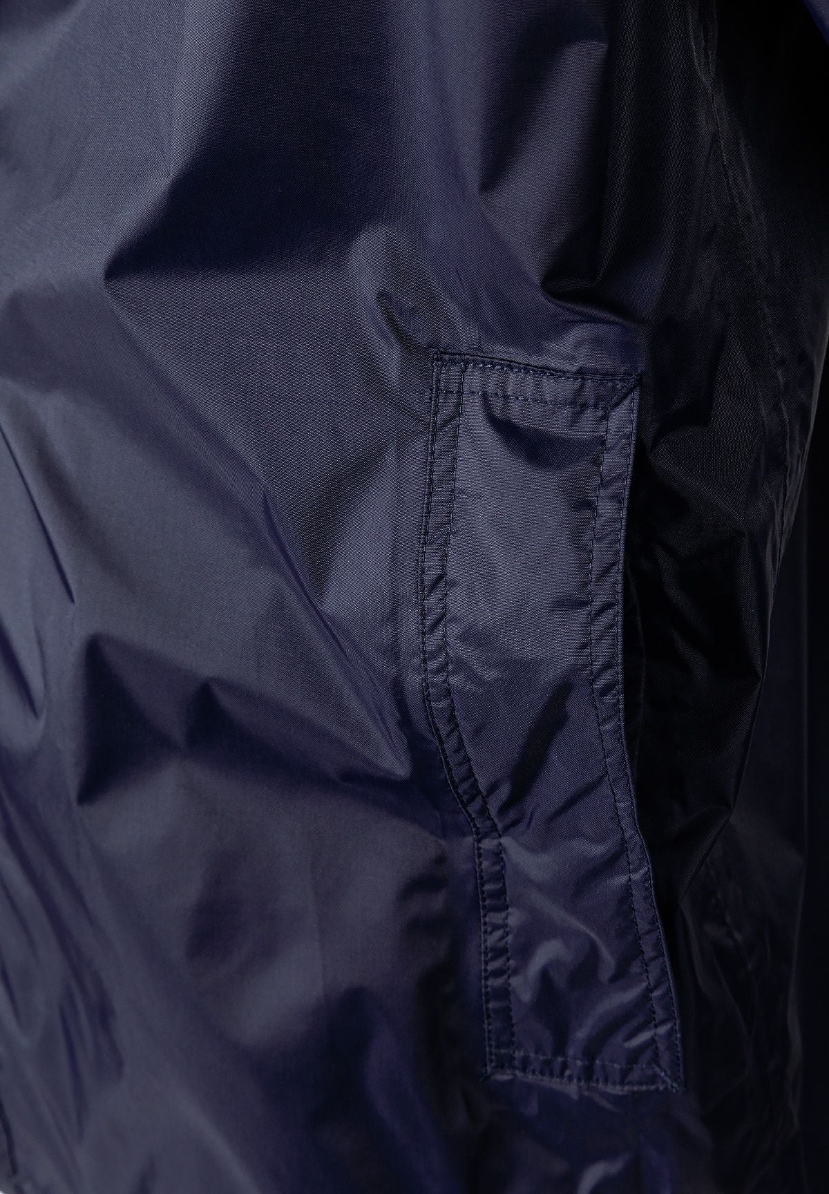Close-up of a navy waterproof jacket featuring a zip pocket.