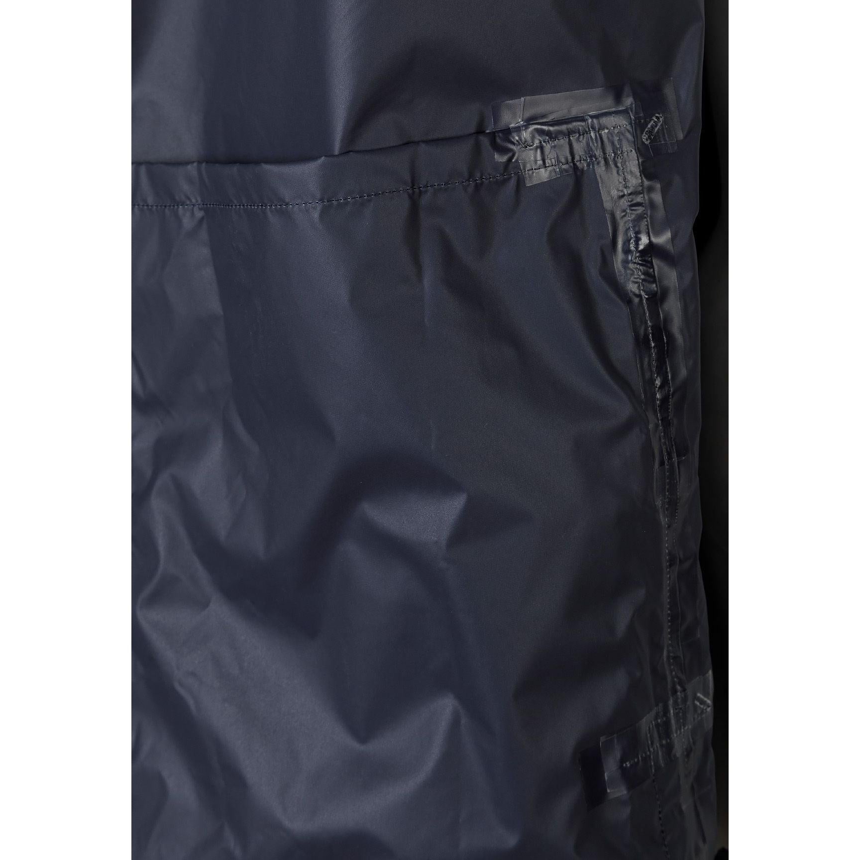 Close-up detail of navy jacket interior showing zip pocket construction and waterproof fabric lining