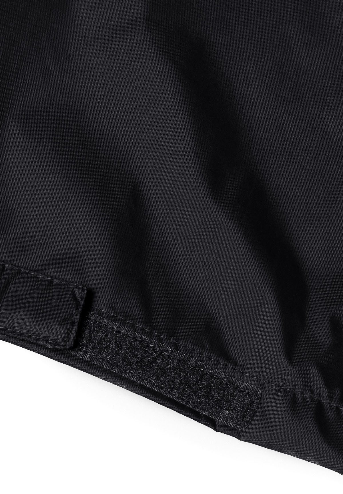Detail of black waterproof overpants with velcro fastener.