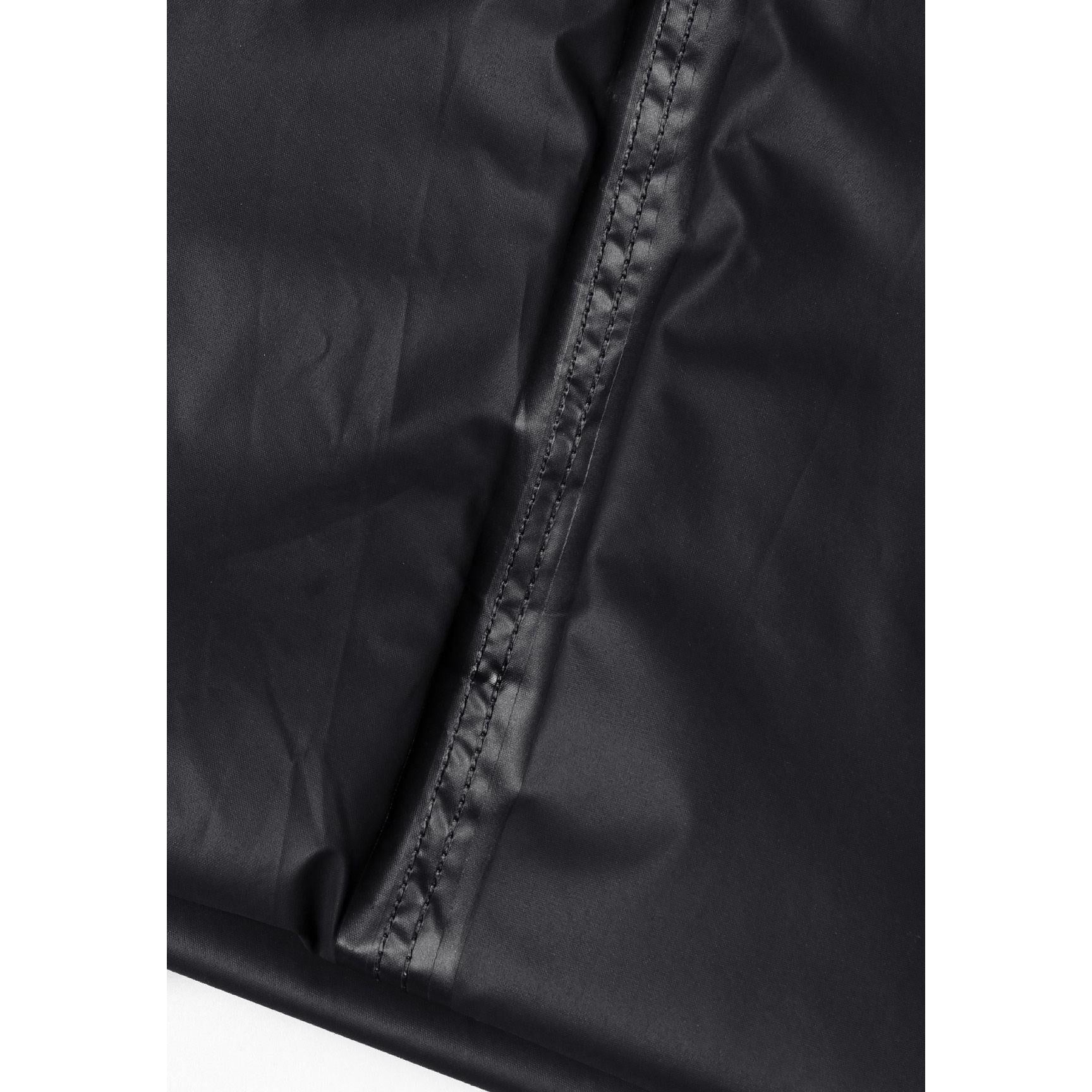 Close-up detail of black waterproof overpants showing side pocket with button closure and adjustable hem with snap fastener