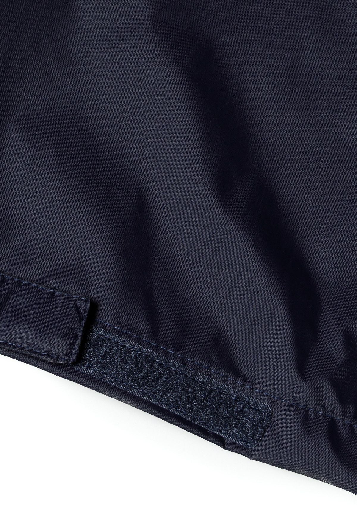 Detail of navy waterproof overpants with velcro cuff.