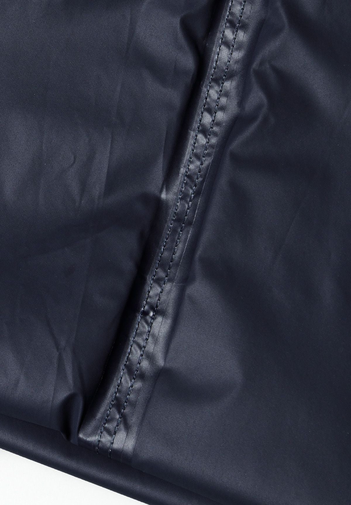 Detail of navy waterproof overpants with elastic waistband and stitching.