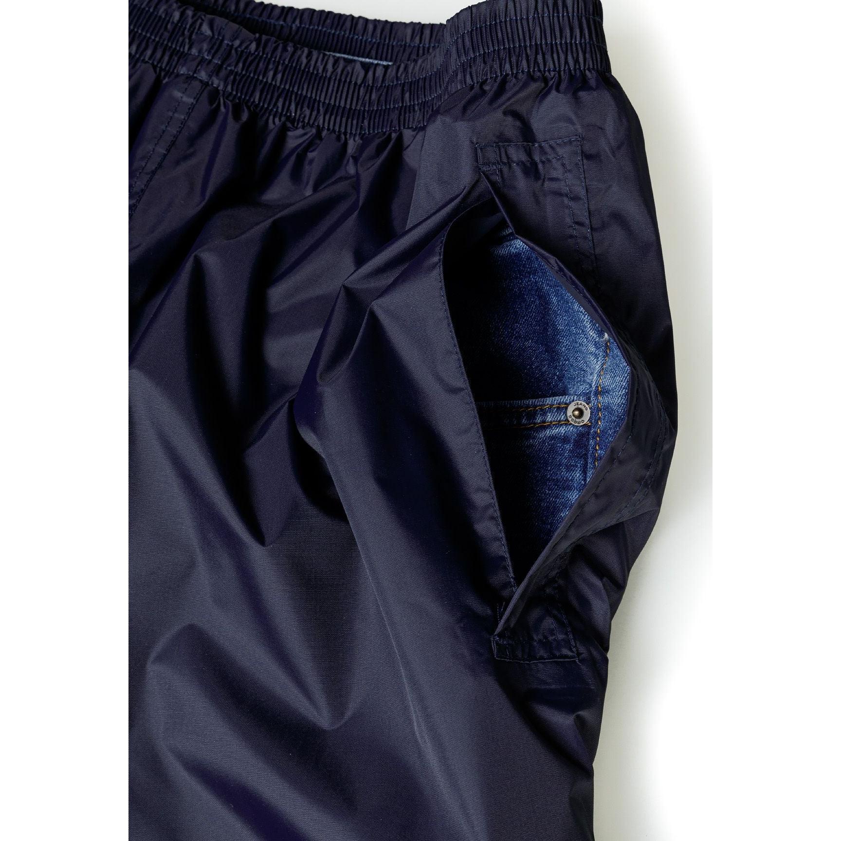 Close-up detail of navy waterproof overpants showing velcro adjustable cuffs and inner blue fabric lining at leg opening