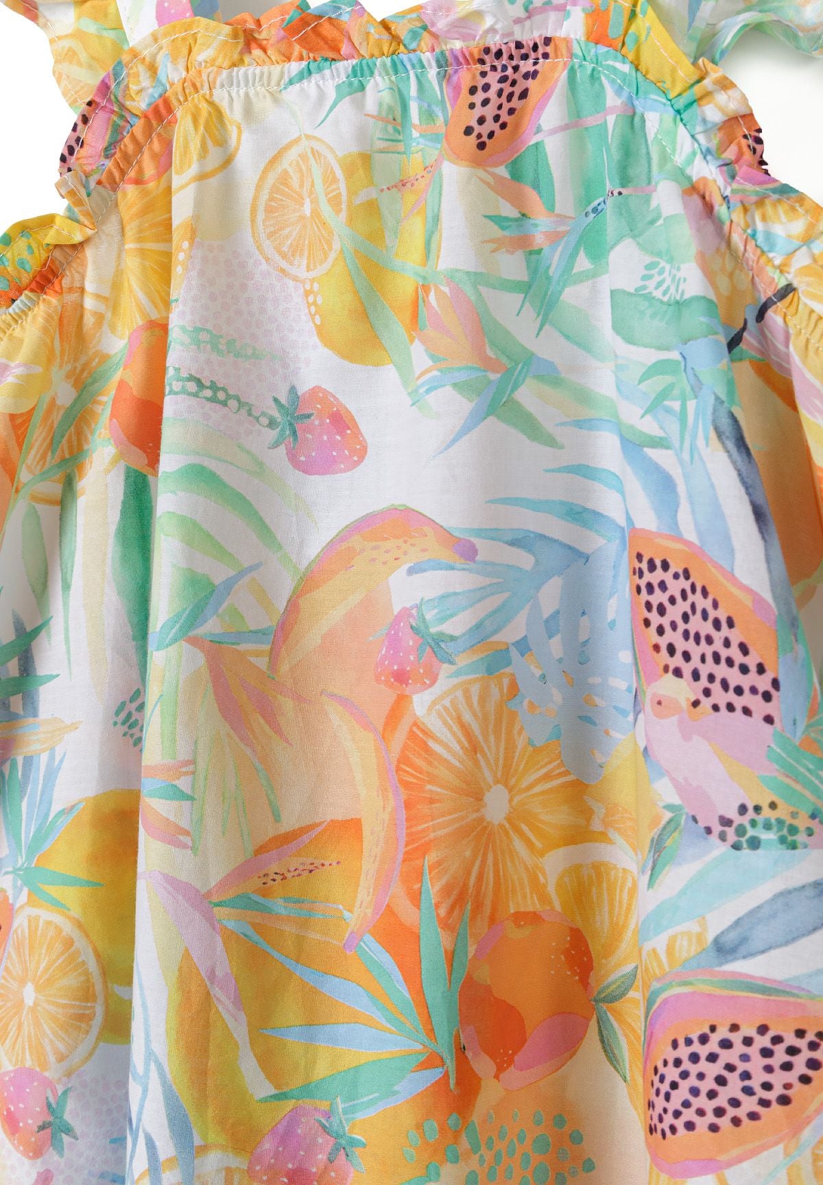 Close-up of sundress print with pink papayas, orange citrus slices, strawberries and green leaves.