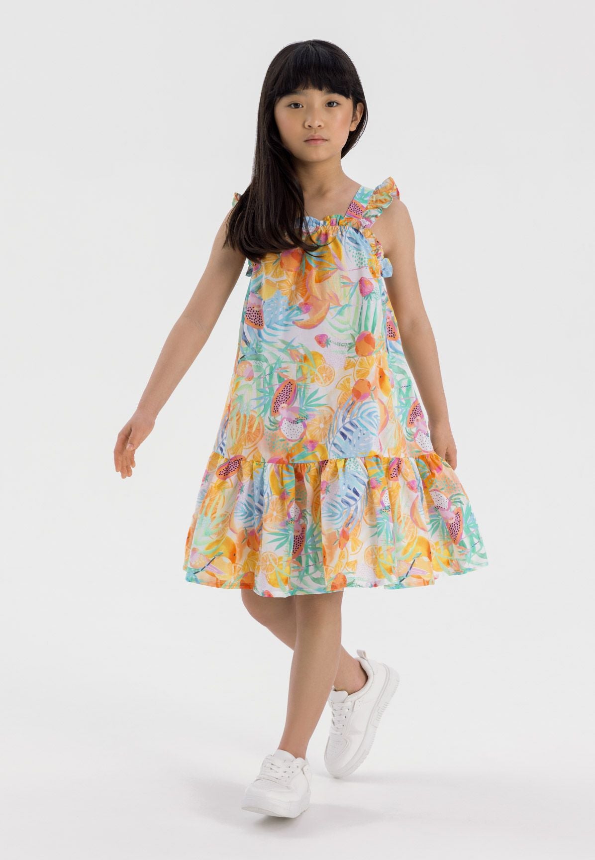White, orange and green tropical print sundress, model front.