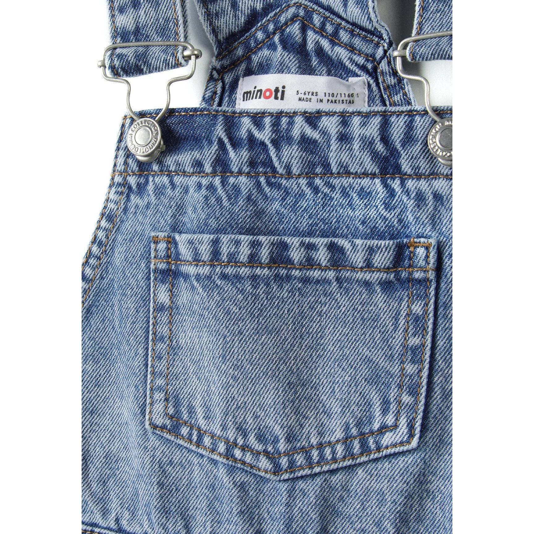 Close-up detail of navy denim dungarees showing Minoti brand label, adjustable brace hardware and front chest pocket construction