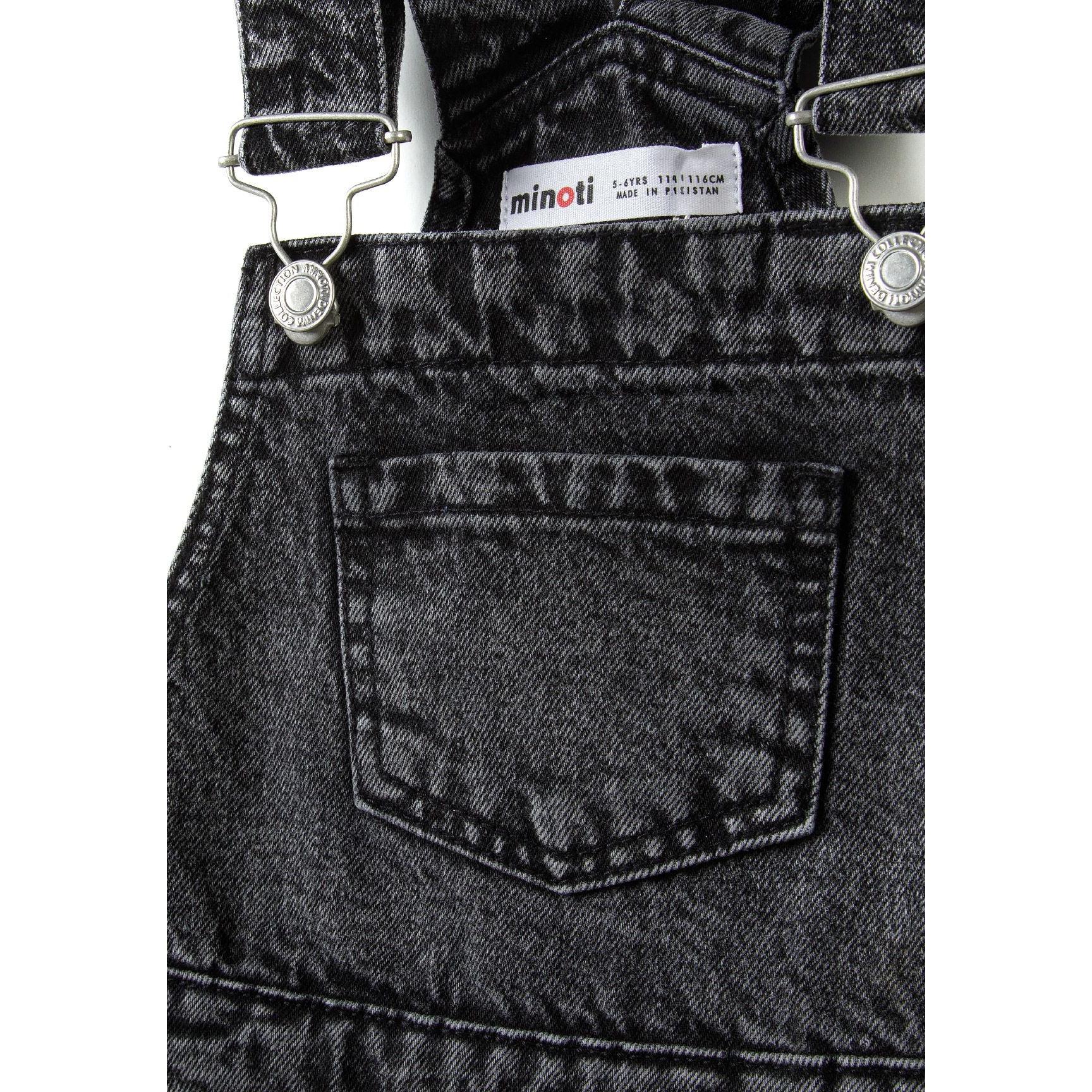 Close-up detail of black denim dungarees showing Minoti label, front pocket and adjustable metal buckles
