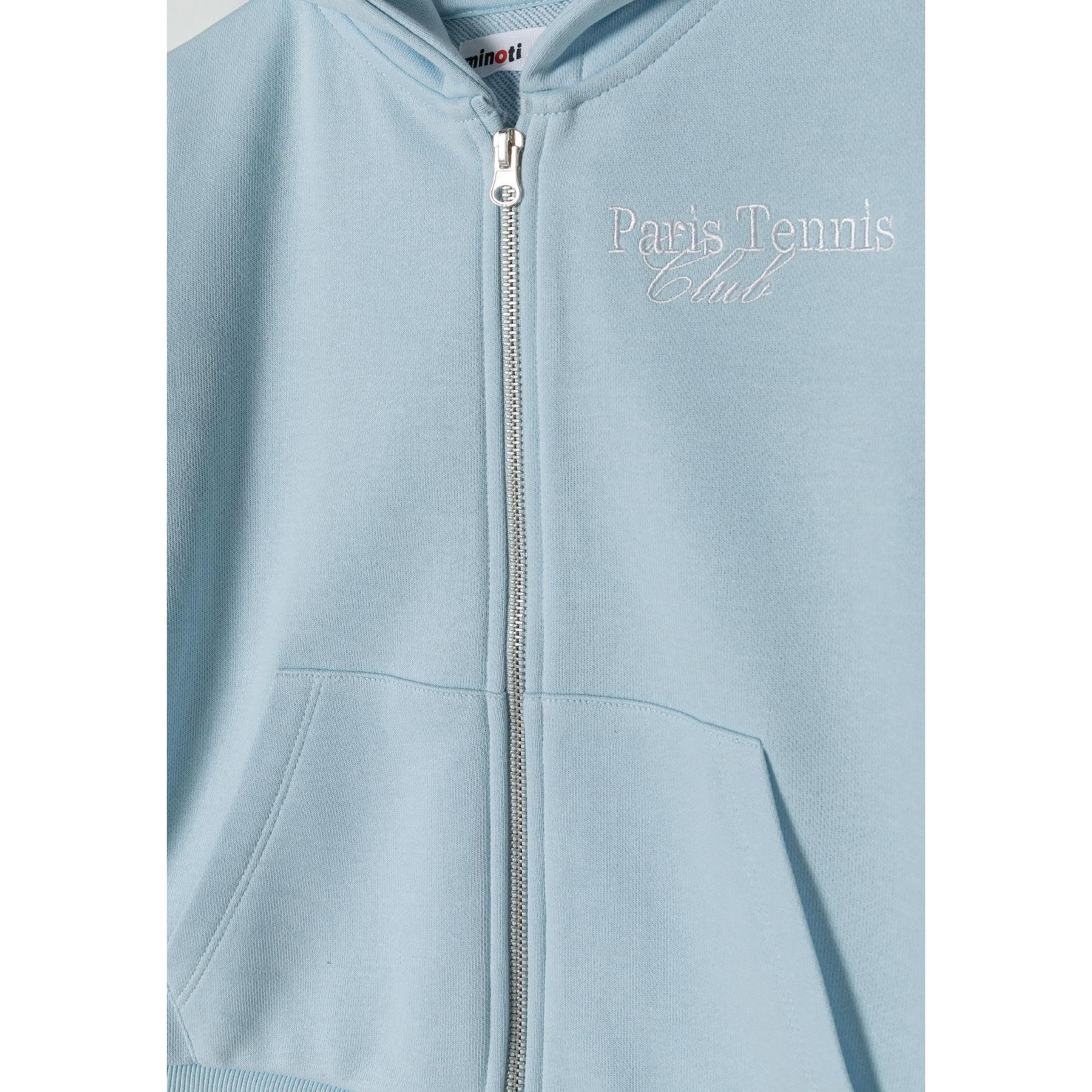 Close-up detail of light blue zip hoodie showing embroidered 'Paris Tennis Club' text, full zip closure and front pocket