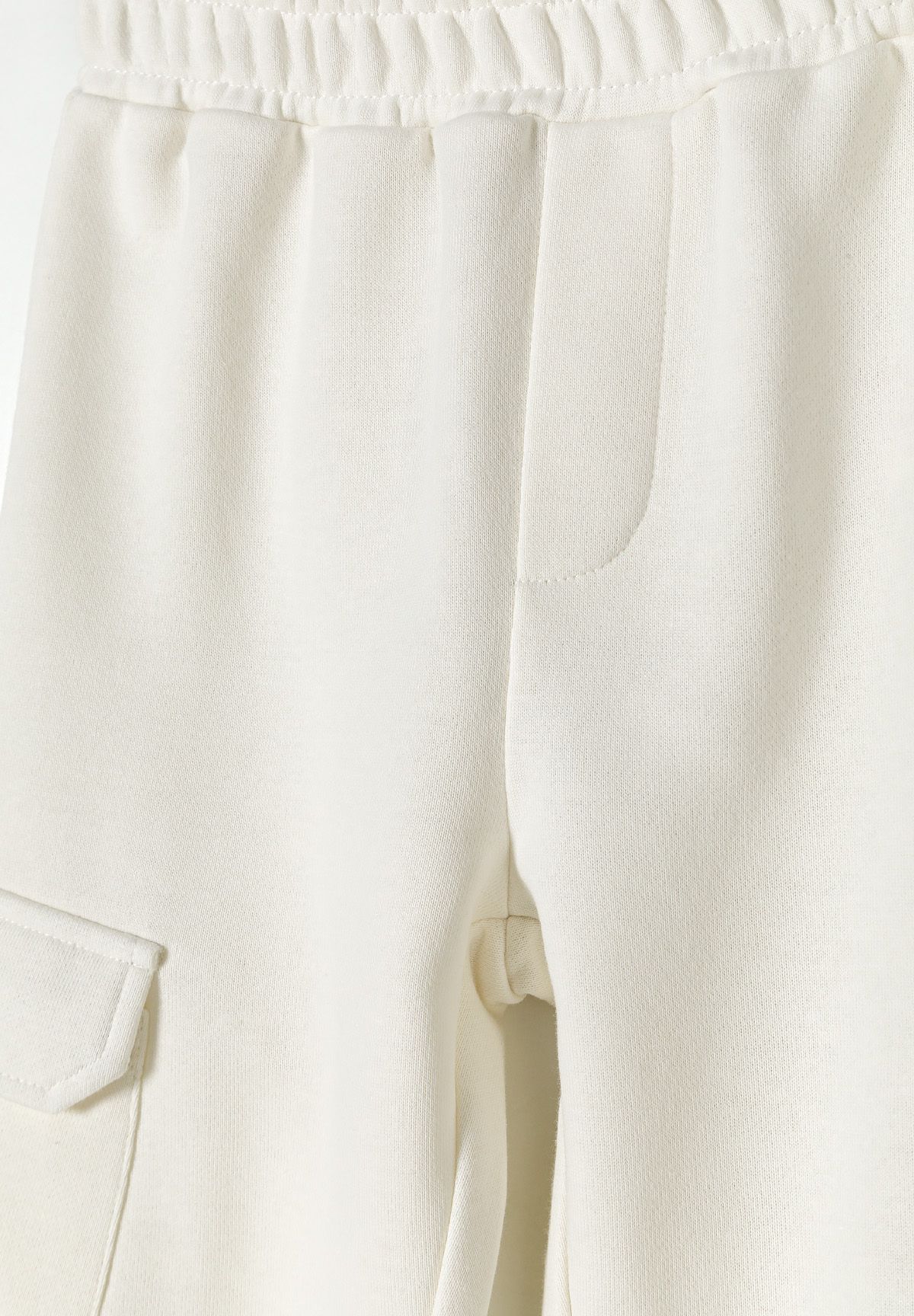 Detail of girls' white fleece cargo joggers with elasticated waistband and side pocket.