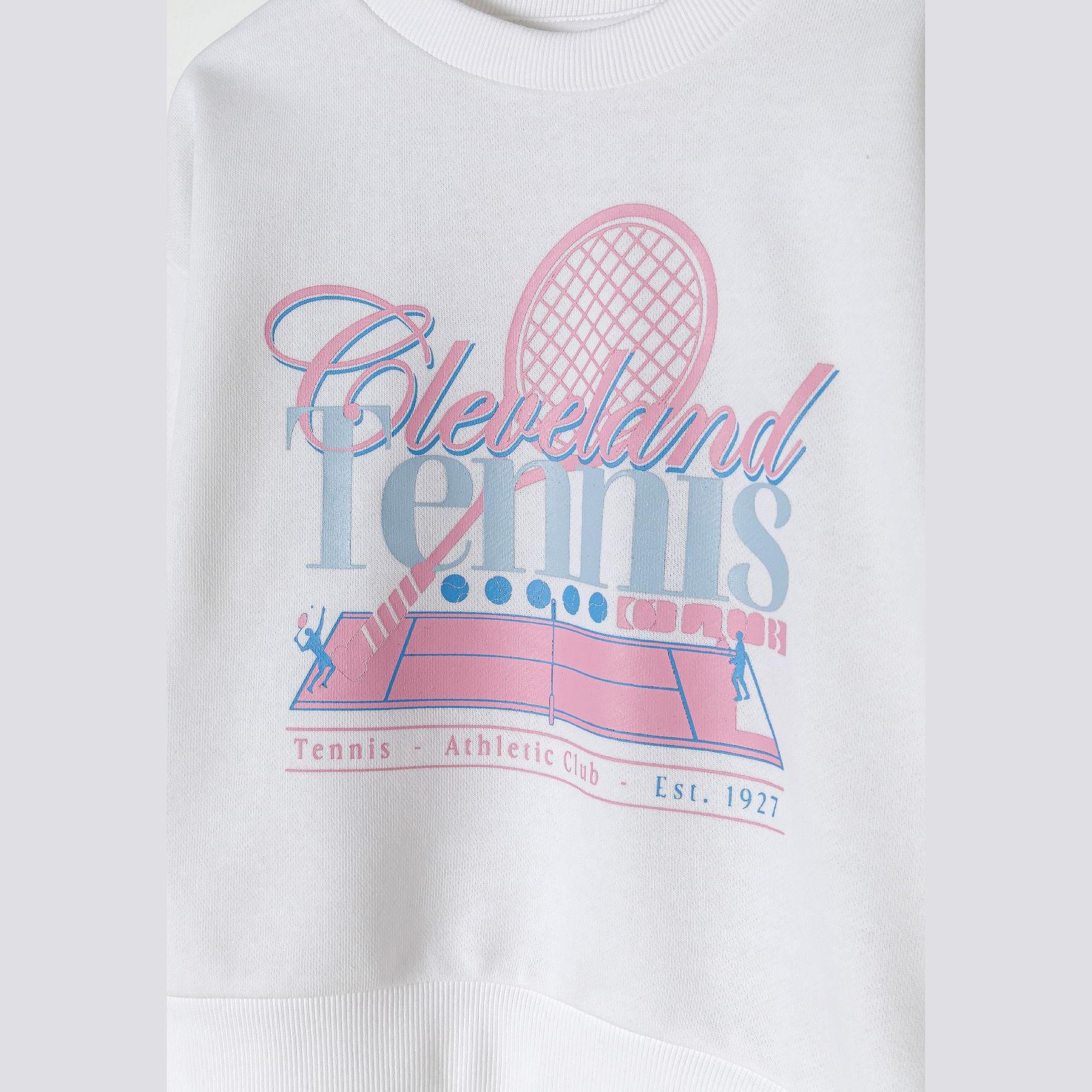 Close-up detail of Cleveland Tennis print on cream sweatshirt showing vintage-style graphics with tennis racket and court design