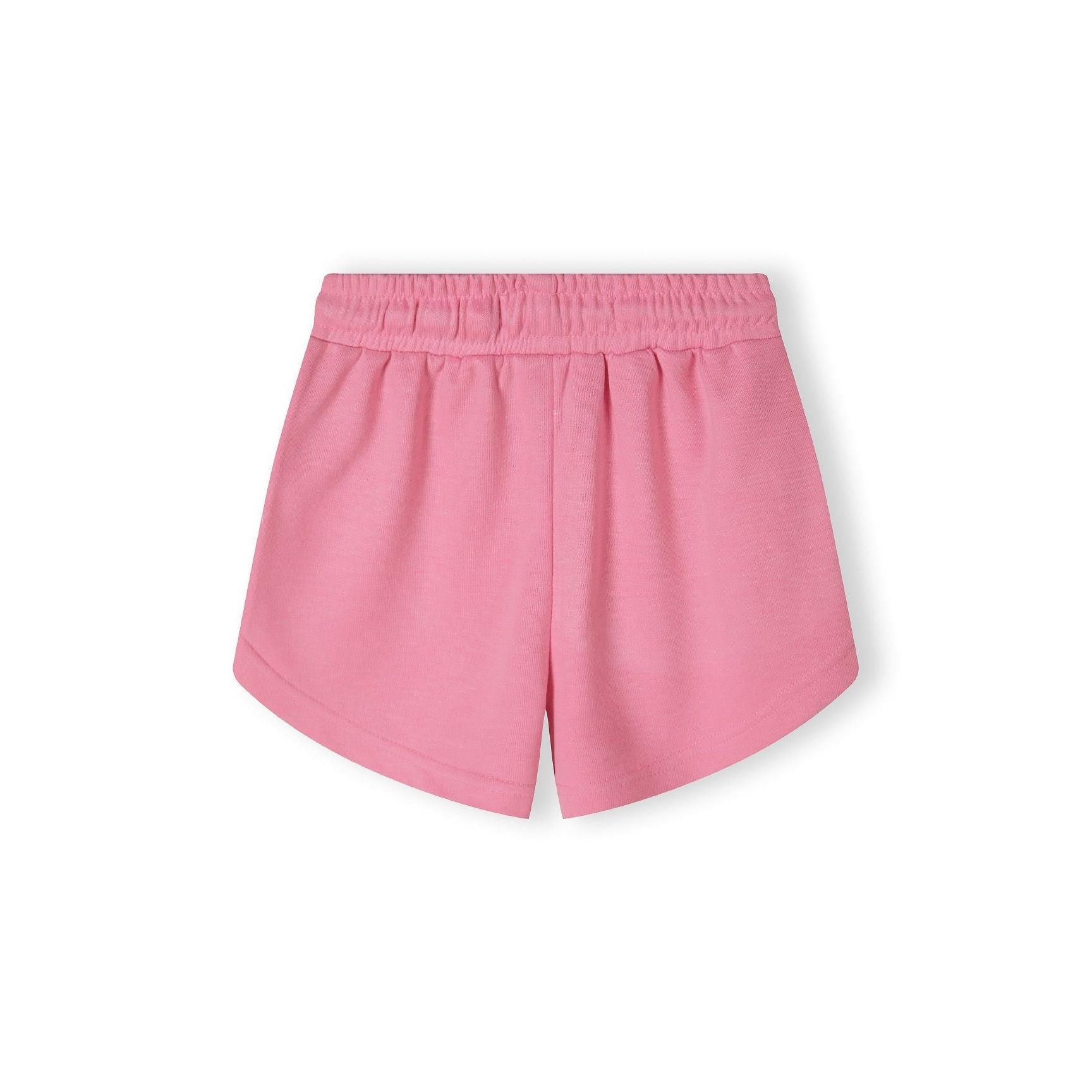 Close-up detail of pink shorts showing side pocket with 'Paris TeamGirl' text printed along the seam