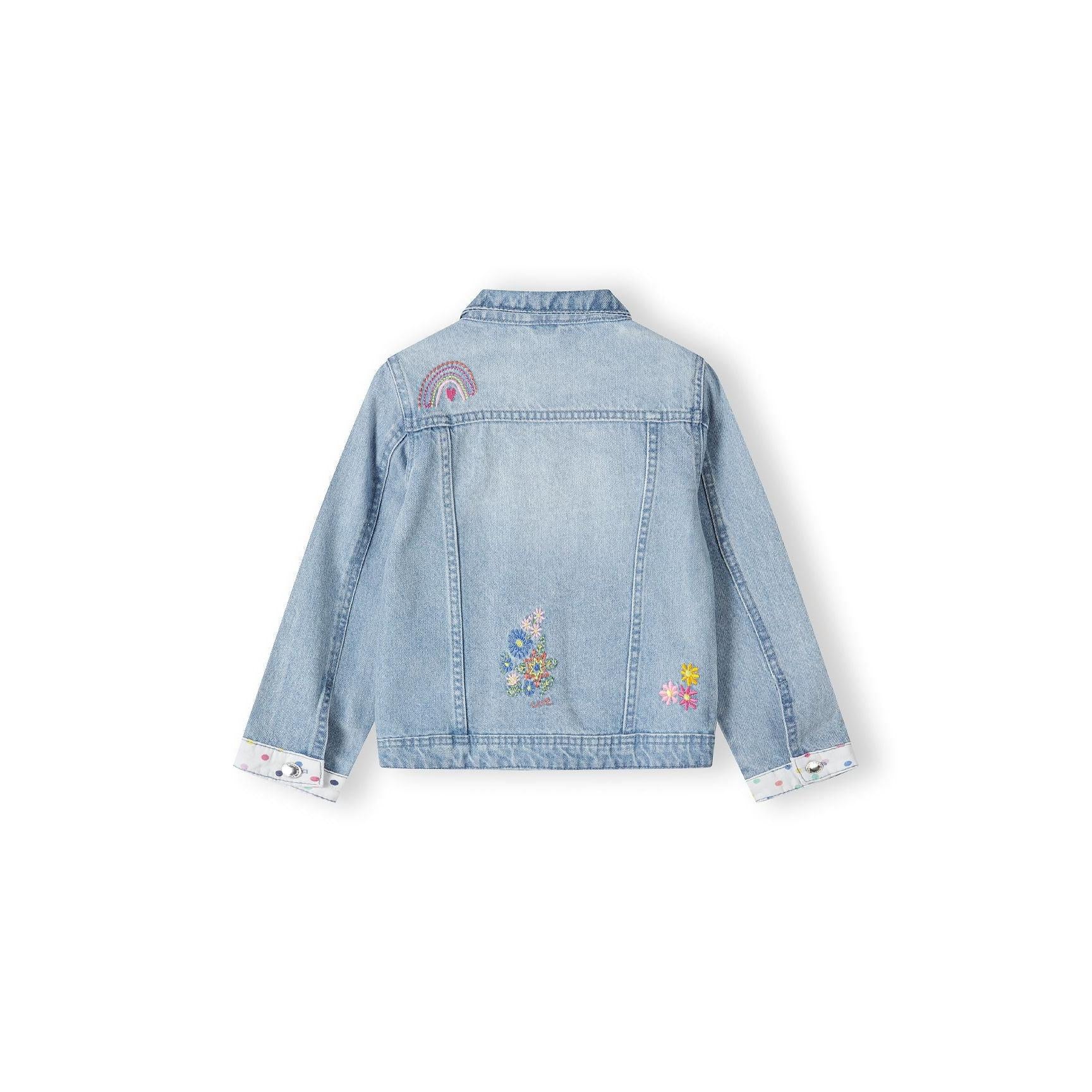 Back view of light blue denim jacket laid flat showing embroidered rainbow and floral details on shoulders and back panel