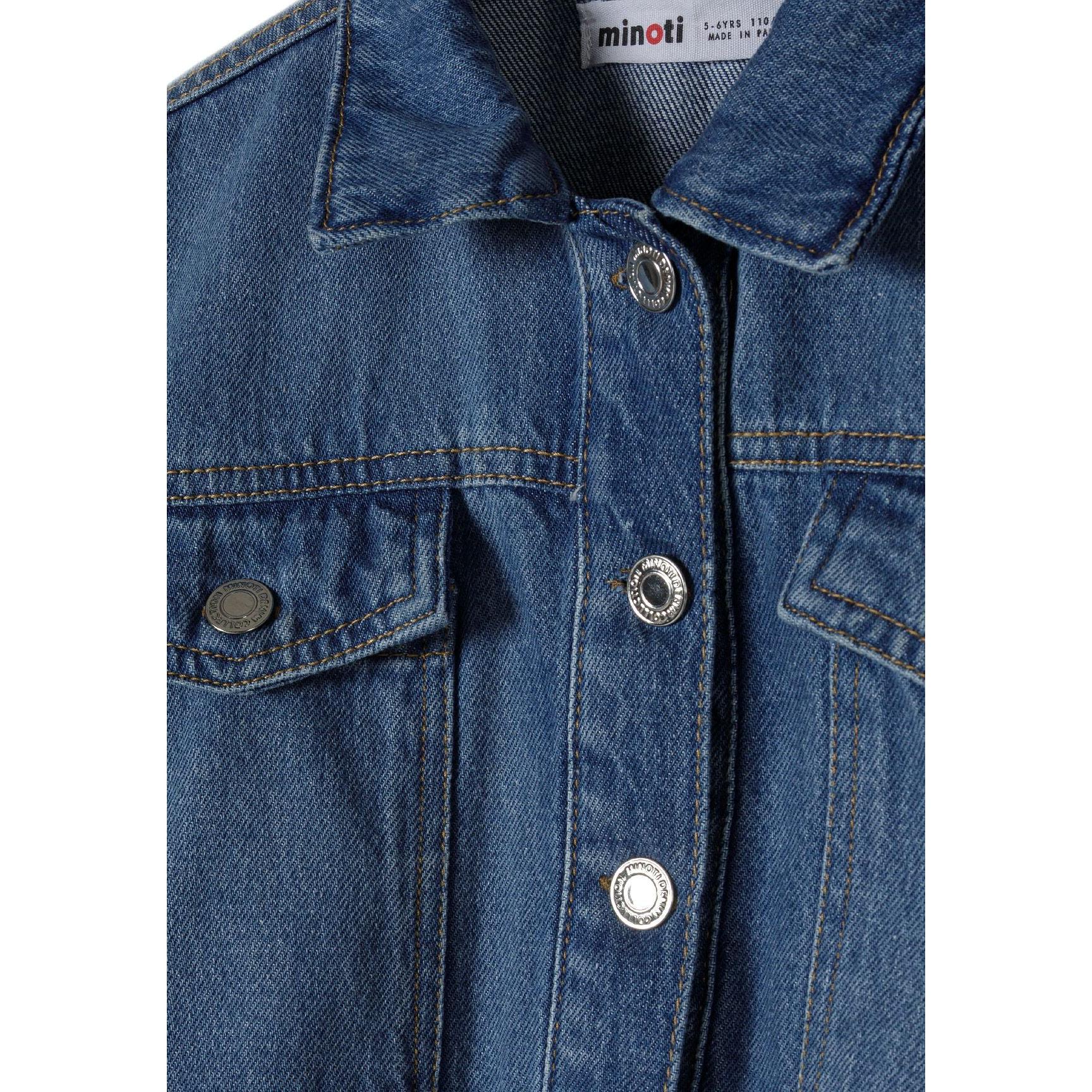 Close-up detail of navy denim jacket showing Minoti label, button fastening, chest pockets and classic denim construction