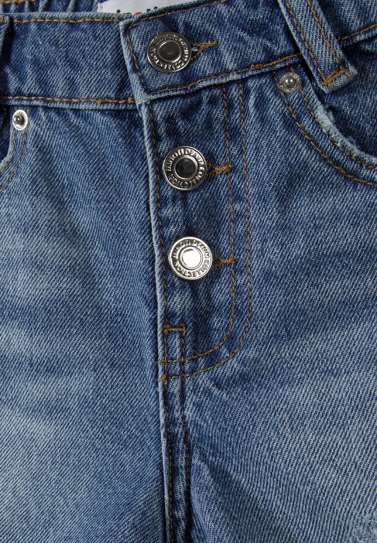 Detail of girls' navy denim shorts with frayed hems and button fastening.