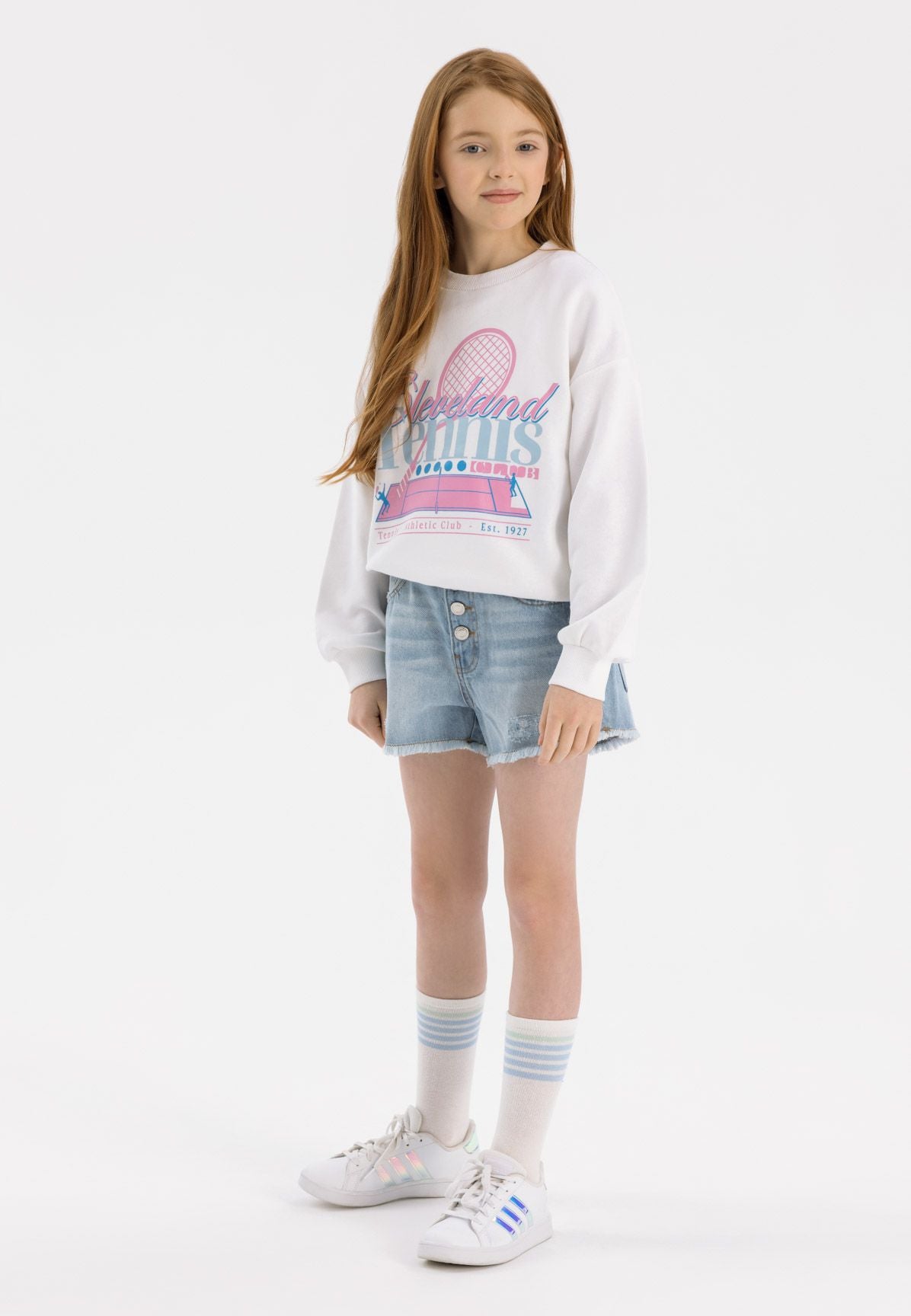 Girls light blue denim shorts with frayed hem, front view, featuring button fastening and pockets.