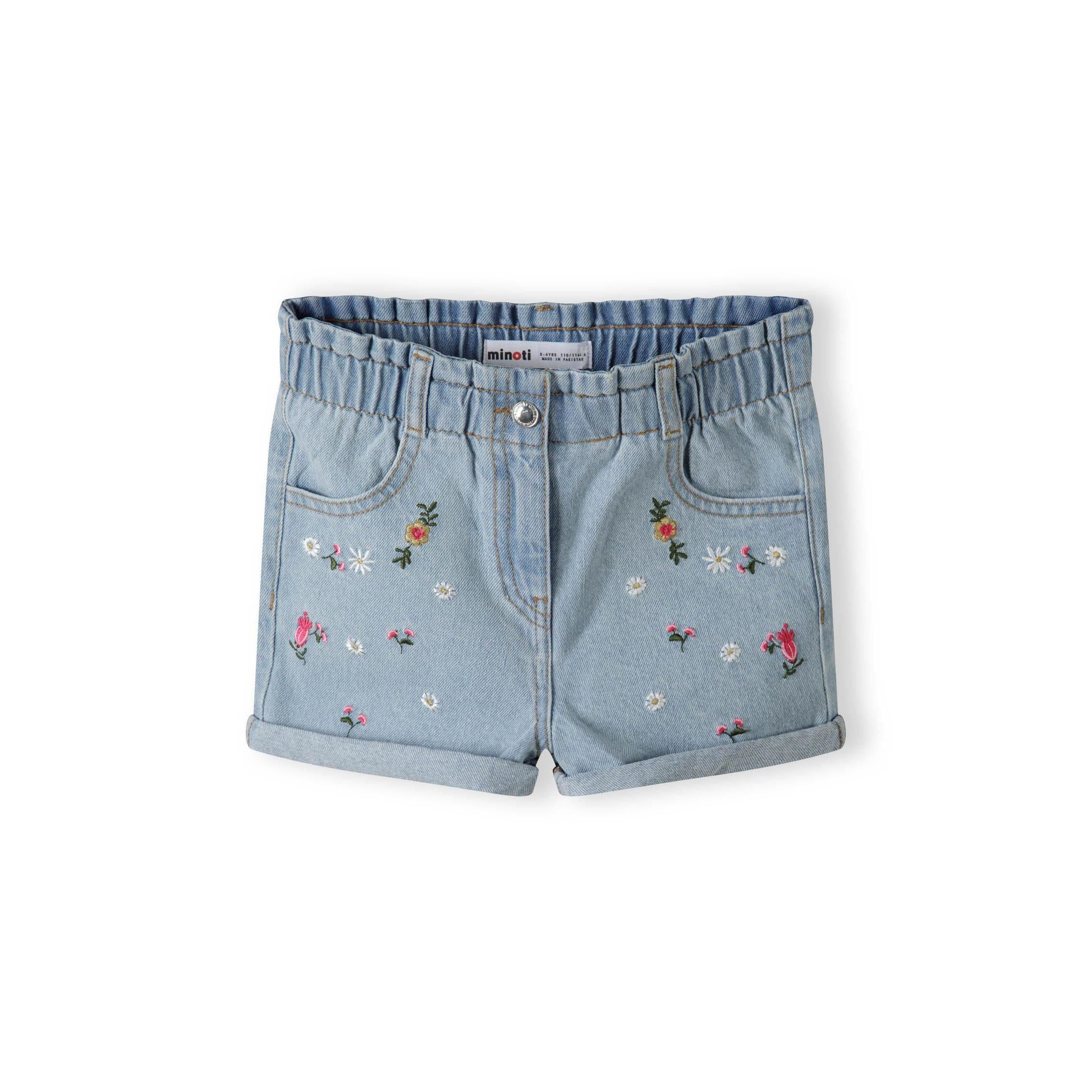 Light blue denim shorts with floral embroidery on white background, front view showing paperbag waistband and rolled cuffs