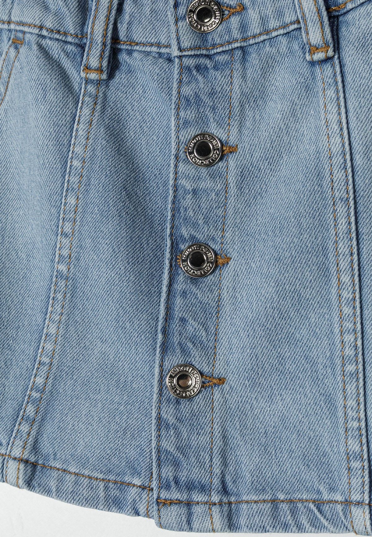 Detail of a light blue denim skirt featuring button fastening and decorative stitching.