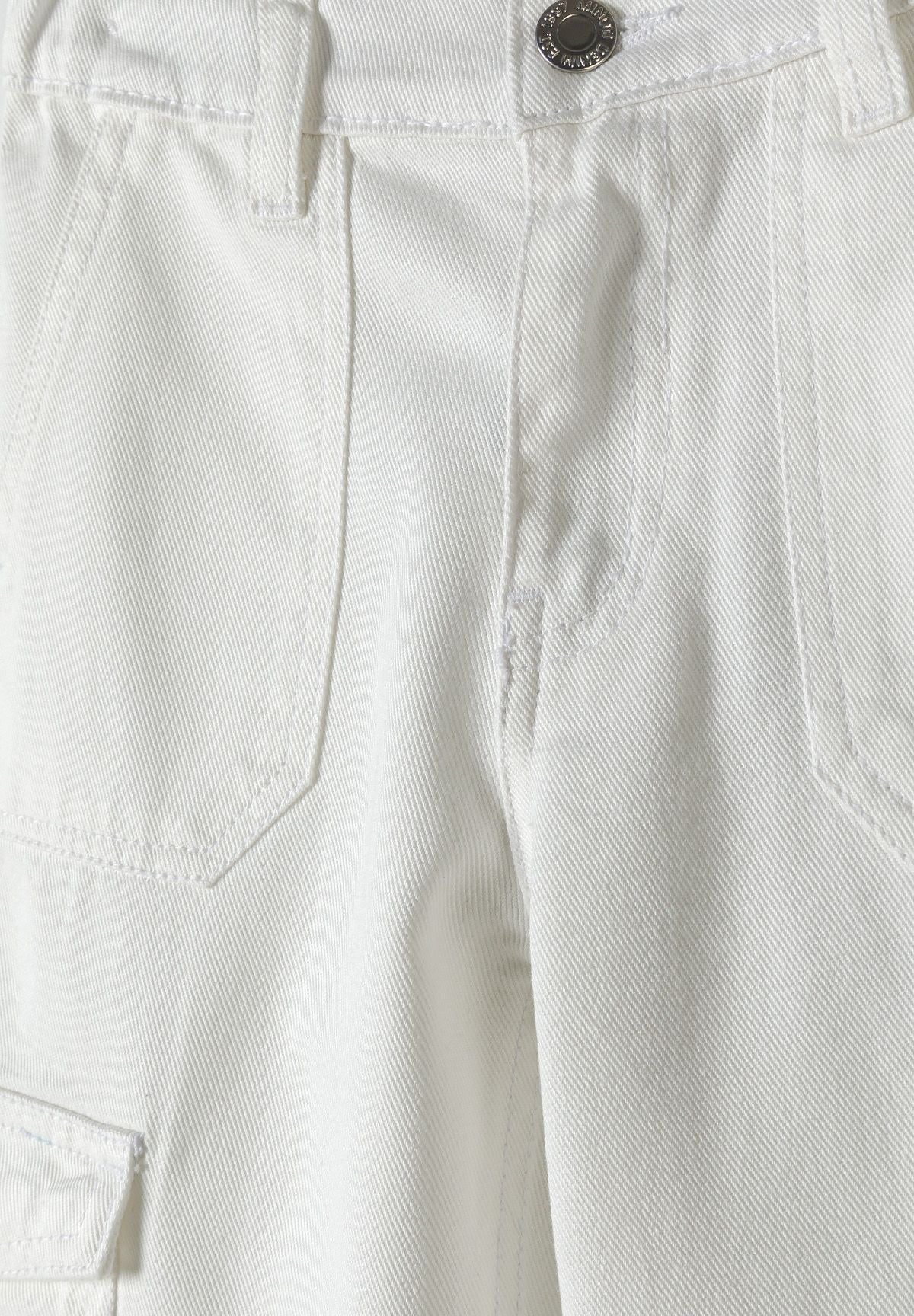 Detail of girls' white wide leg cargo trousers with pockets and button.